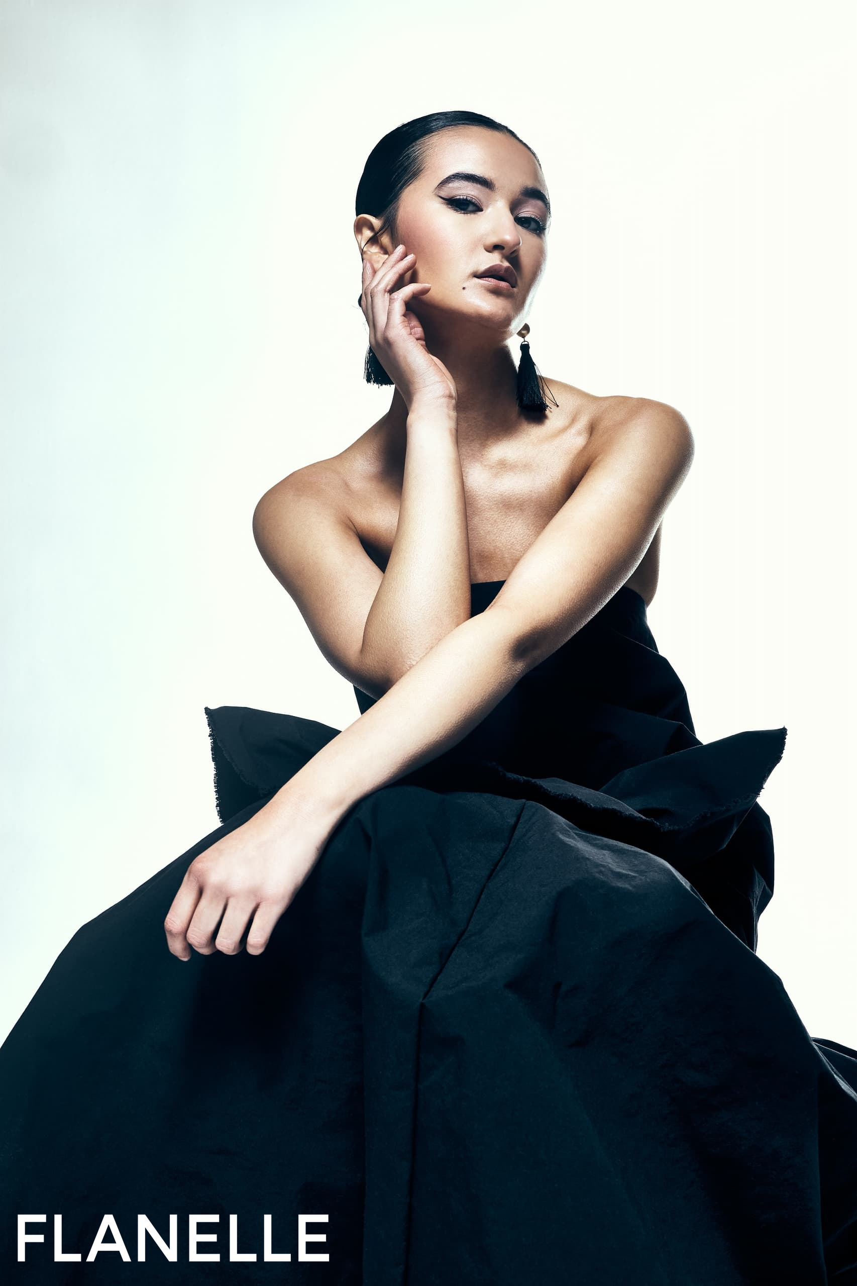 Elegant woman posing in a black dress, featured in Flanelle magazine.