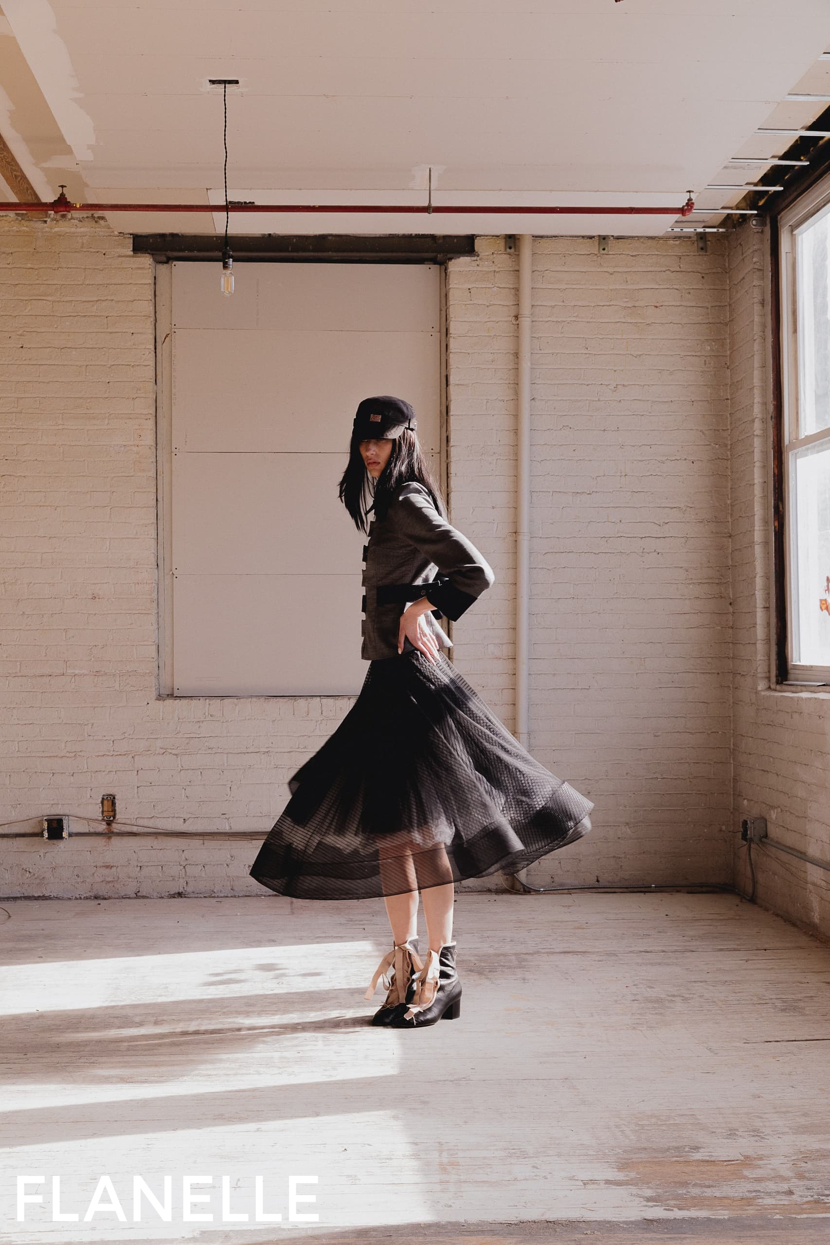 Fashionable person in a stylish outfit spins gracefully in a bright, minimalist space.