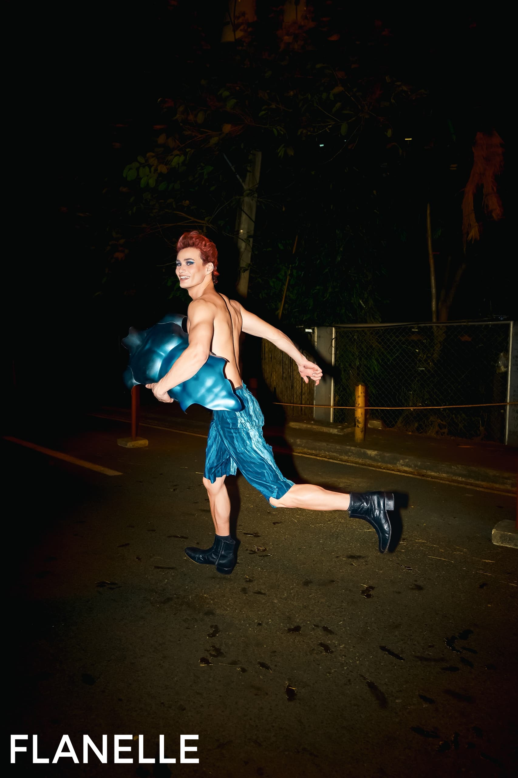 Person in creative outfit running at night on a dimly lit street.