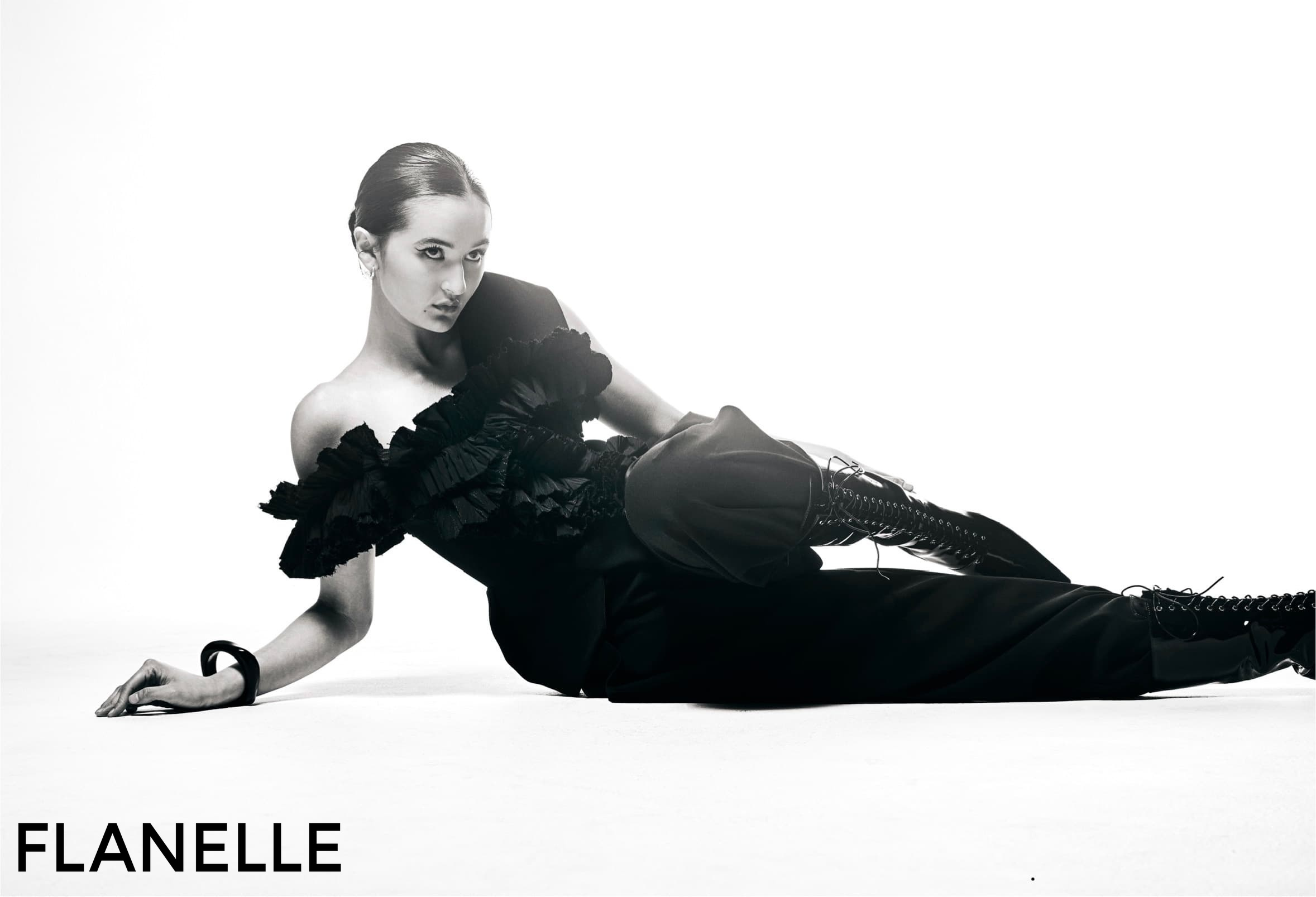 Elegant model in black gown posing for fashion shoot.