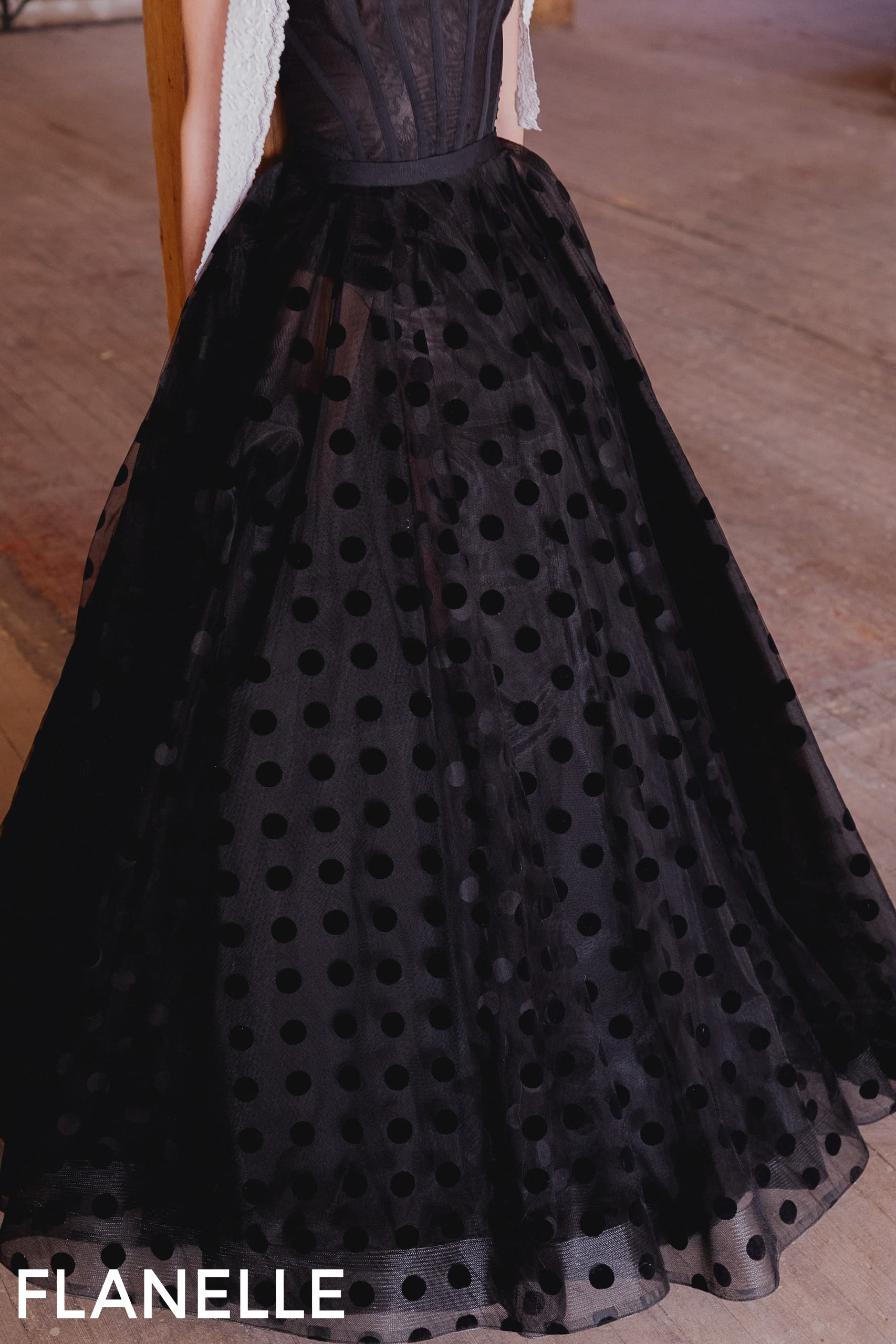 Elegant black polka dot dress with textured fabric and flowy skirt.