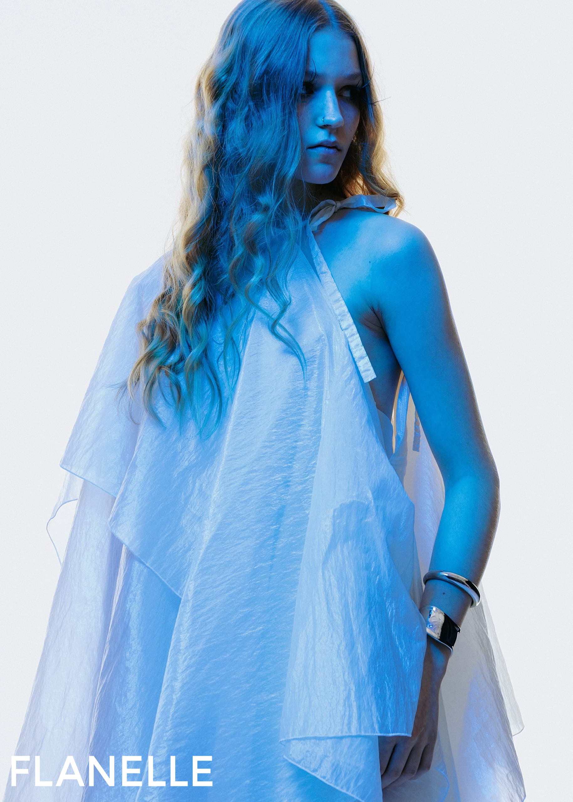 Blue tone fashion shoot with woman in flowy dress, showcasing modern elegance.