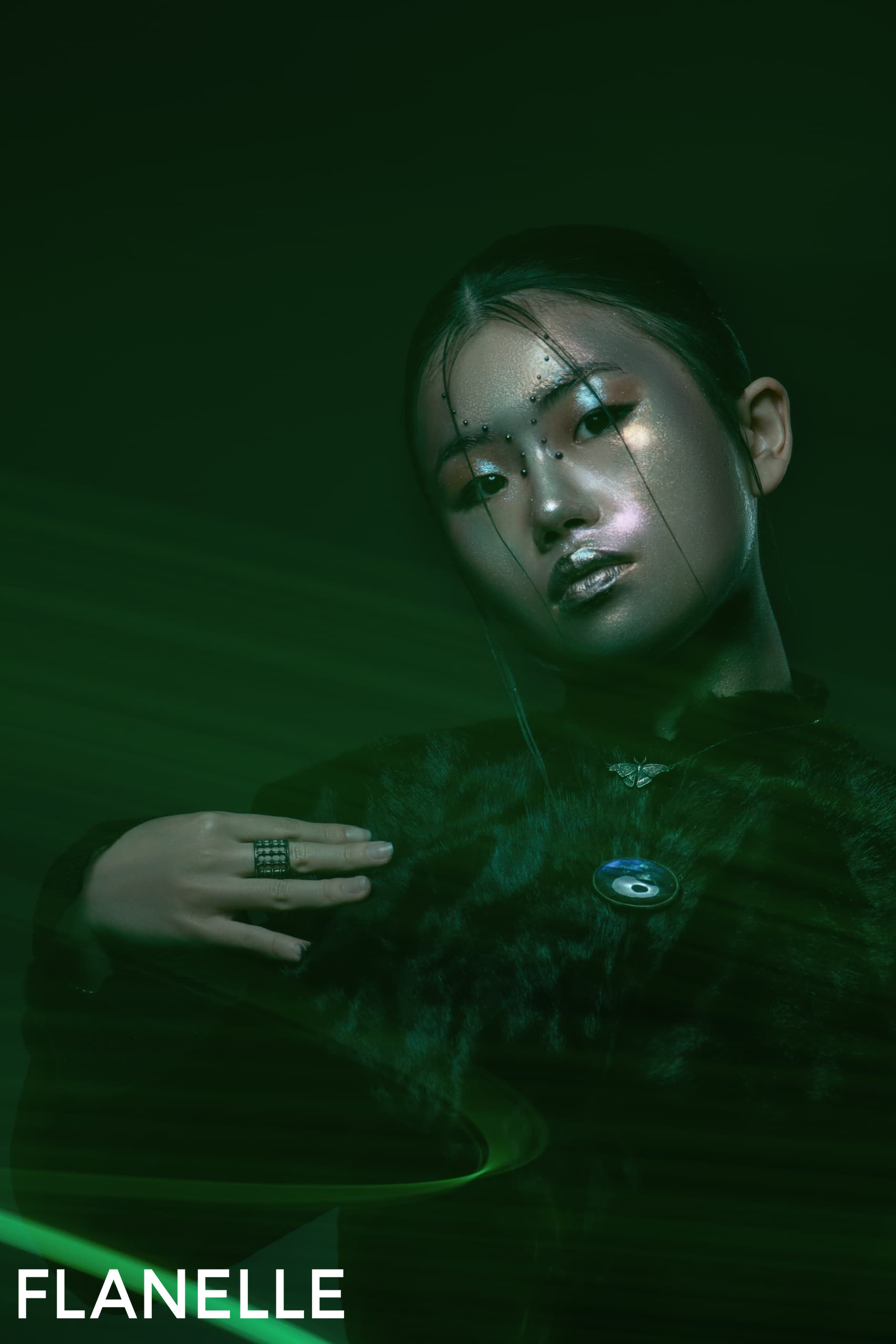 Futuristic fashion portrait with green lighting and metallic makeup.