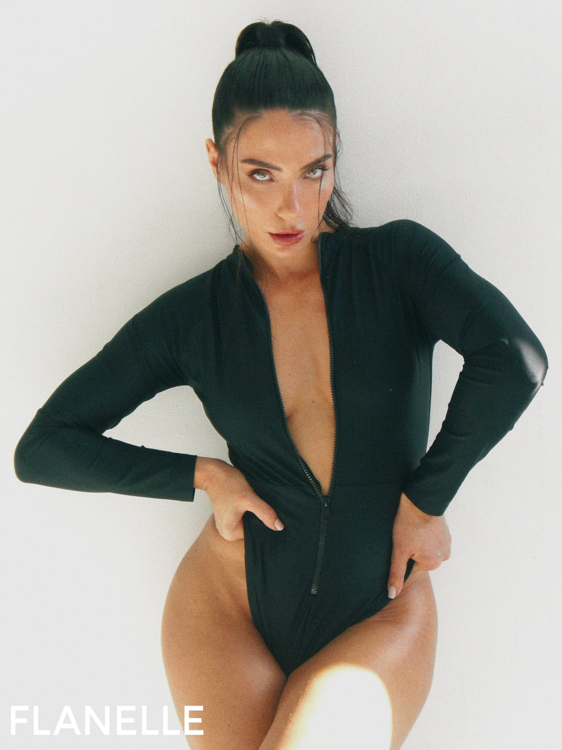 Model in black bodysuit poses for Flanelle Magazine fashion shoot.