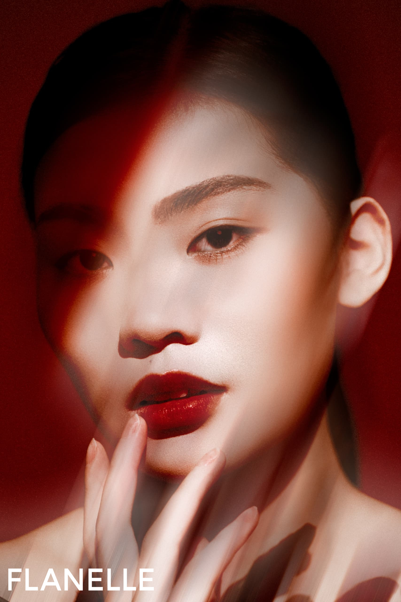 Striking portrait with dramatic lighting and red accents. Fashionable and artistic.