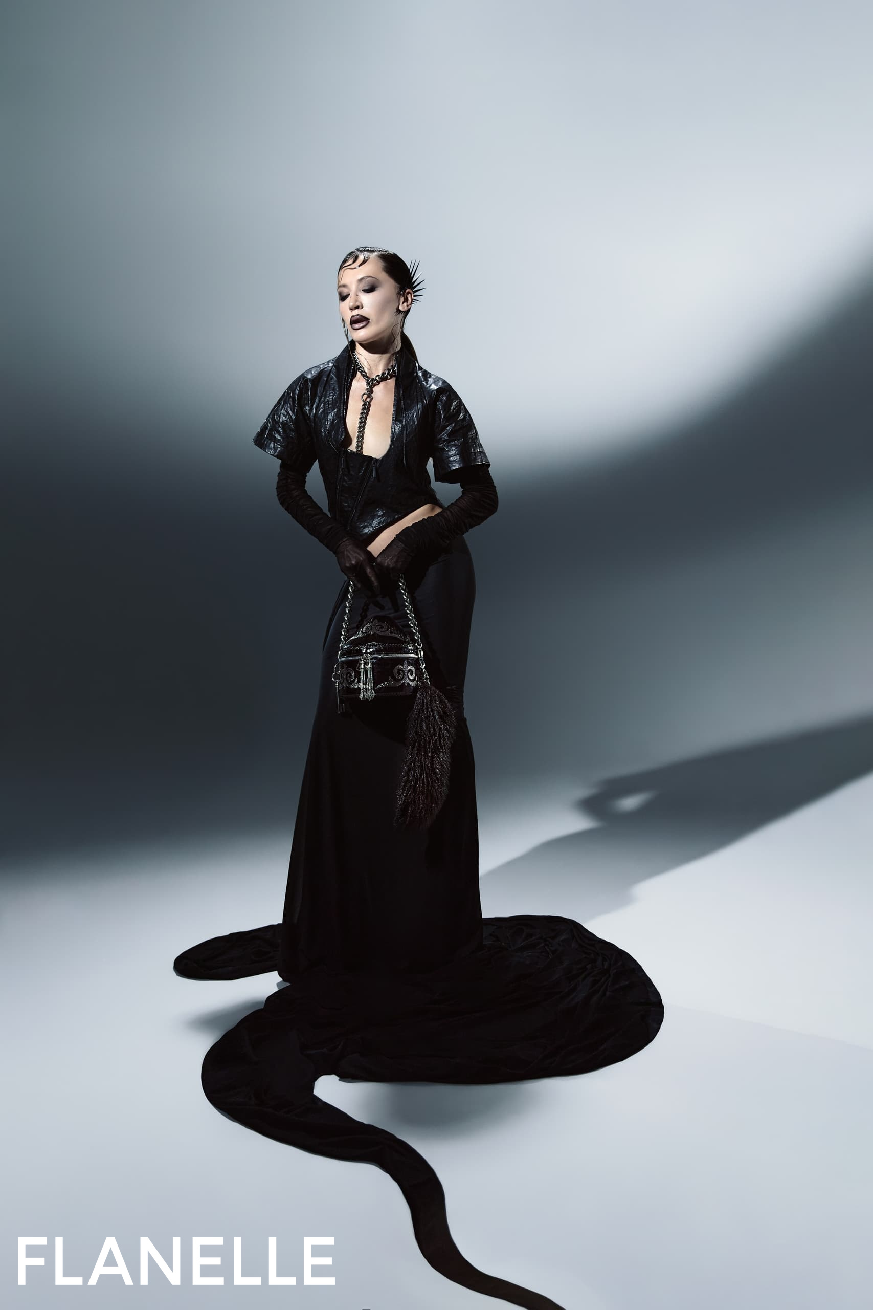 Elegant model in black dress, dramatic shadows, fashion pose. Flanelle magazine.