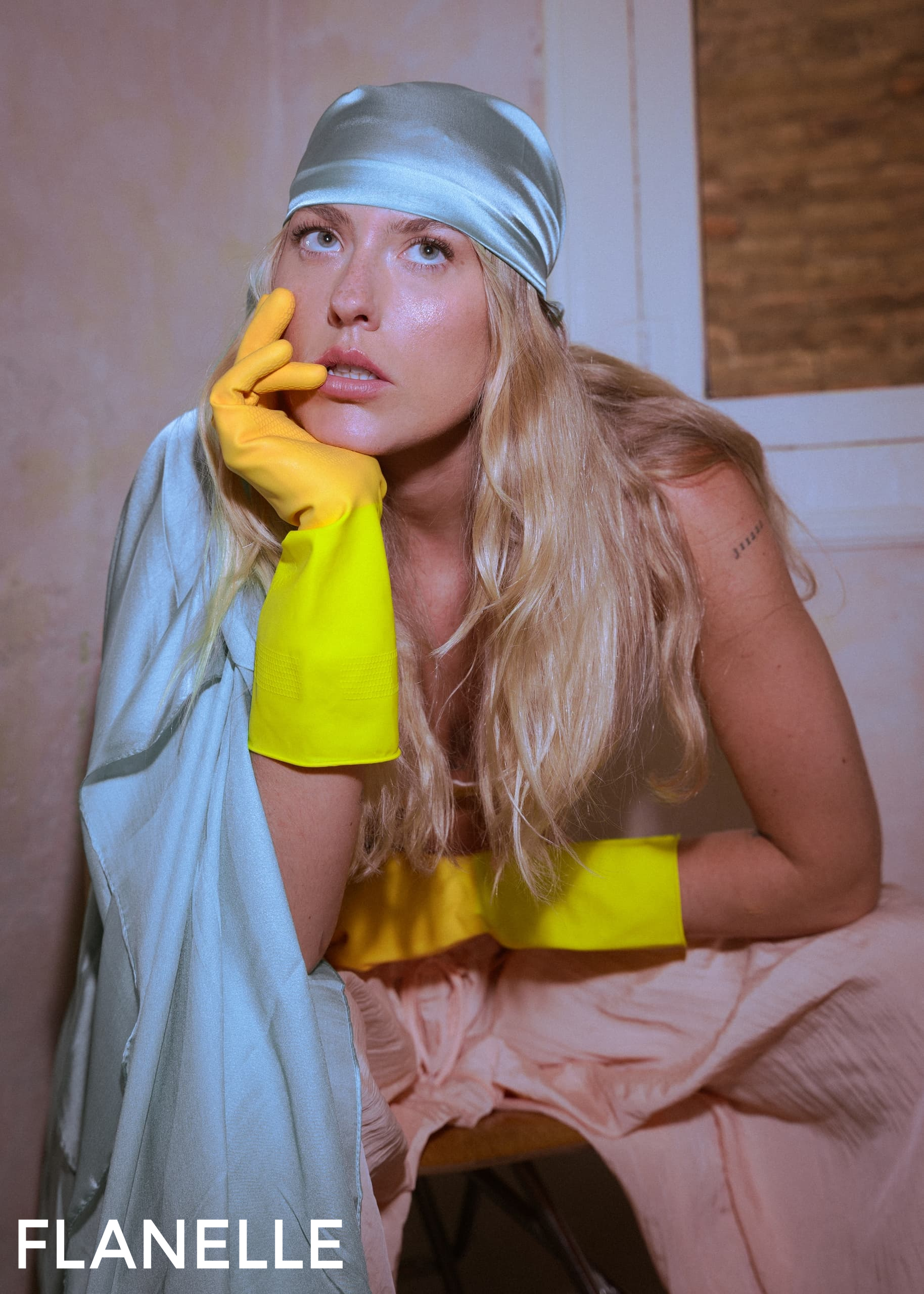 Fashion editorial with model in satin bandana, yellow gloves, and flowing fabric.