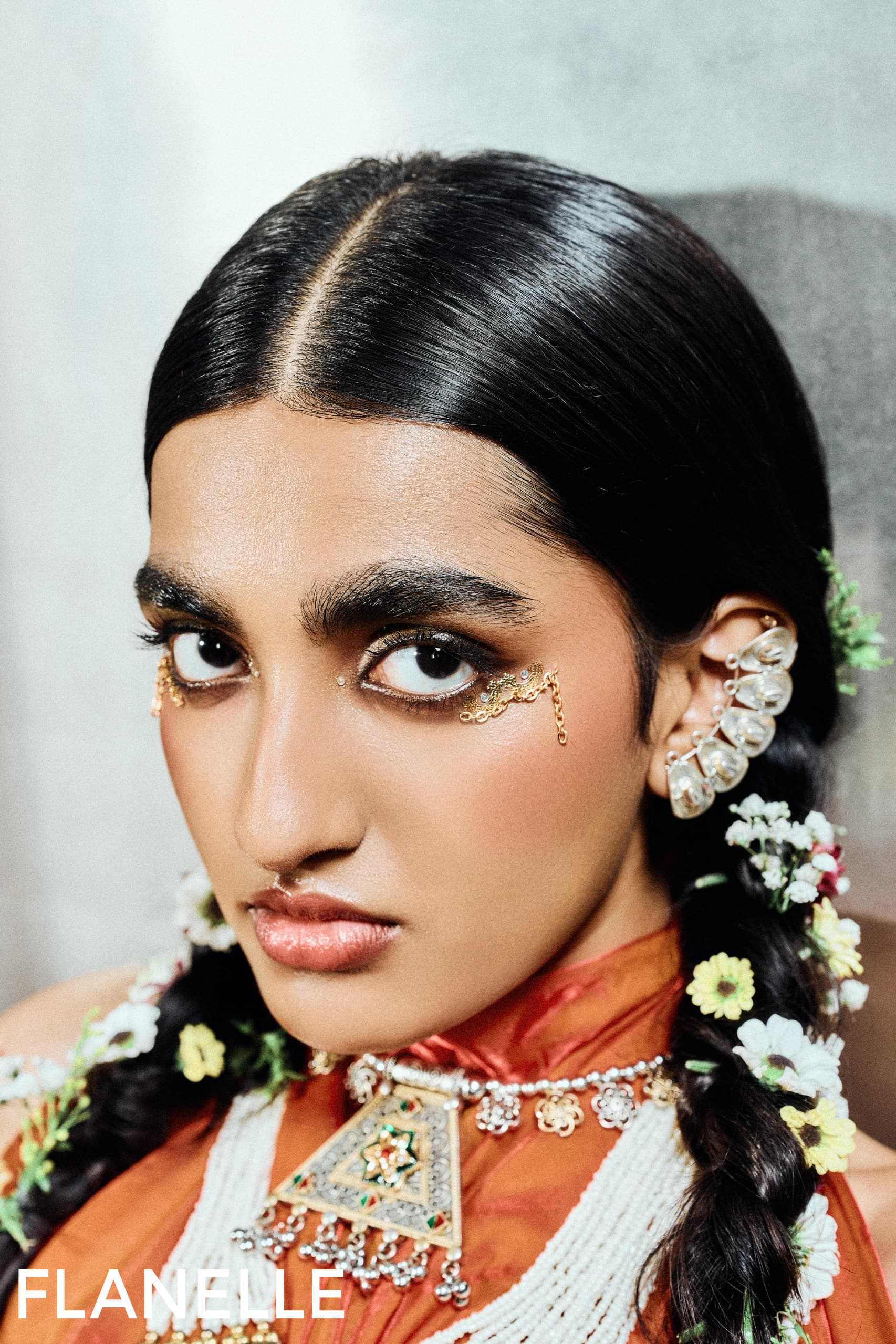 Bold fashion look with intricate jewelry and floral accents.