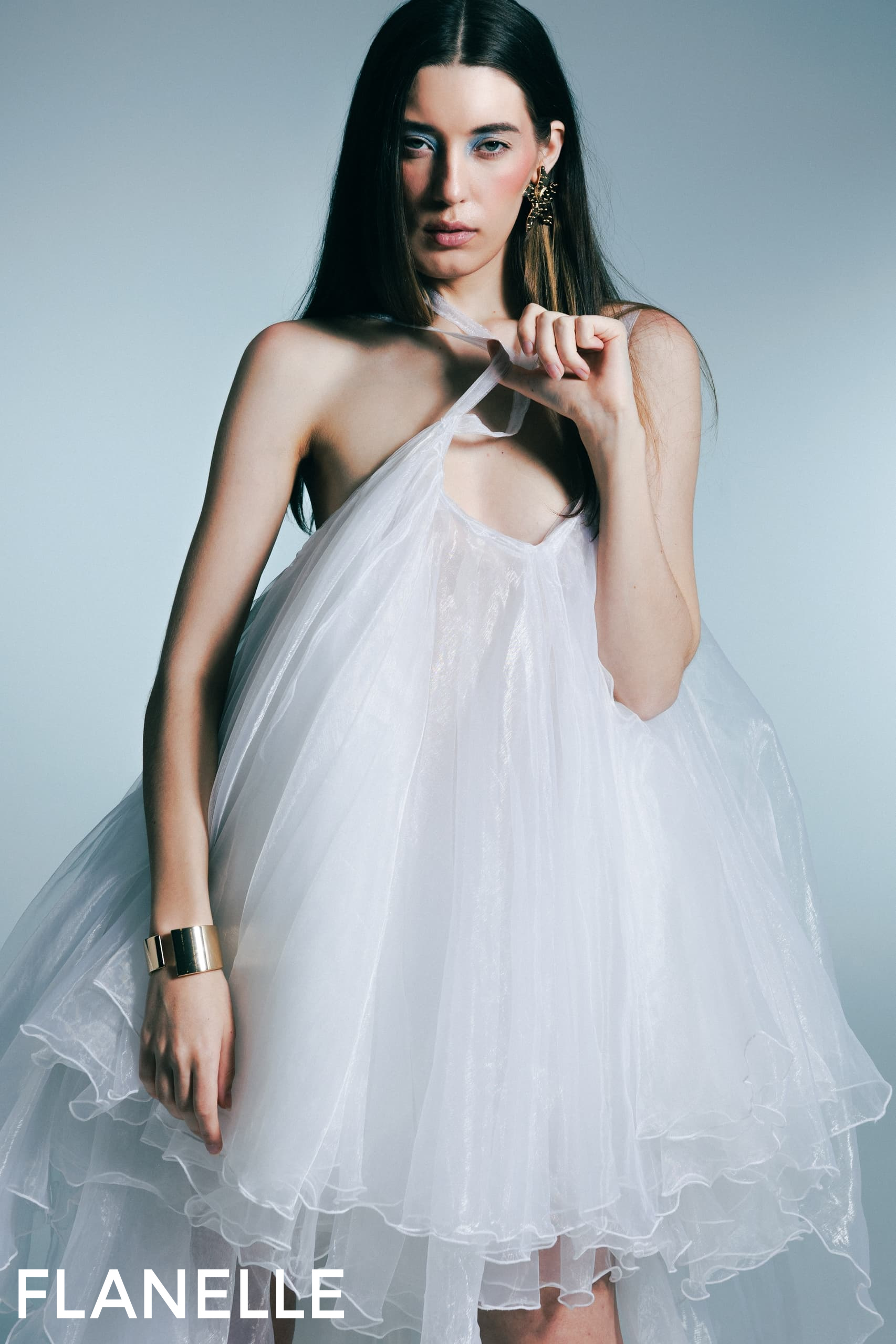 Model wearing ethereal white dress with gold cuff bracelet. Fashion by Flanelle.