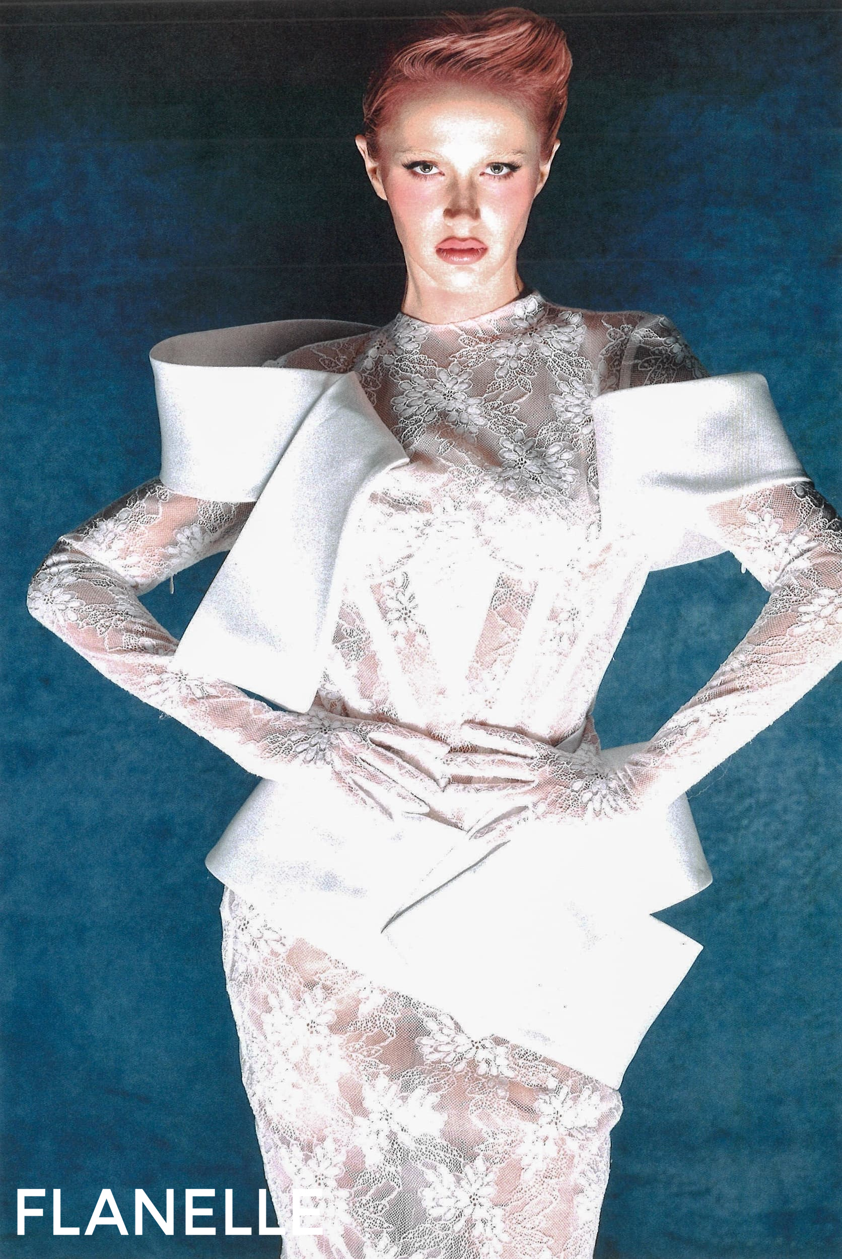 Model in white lace and structured attire on blue background, Flanelle magazine cover.