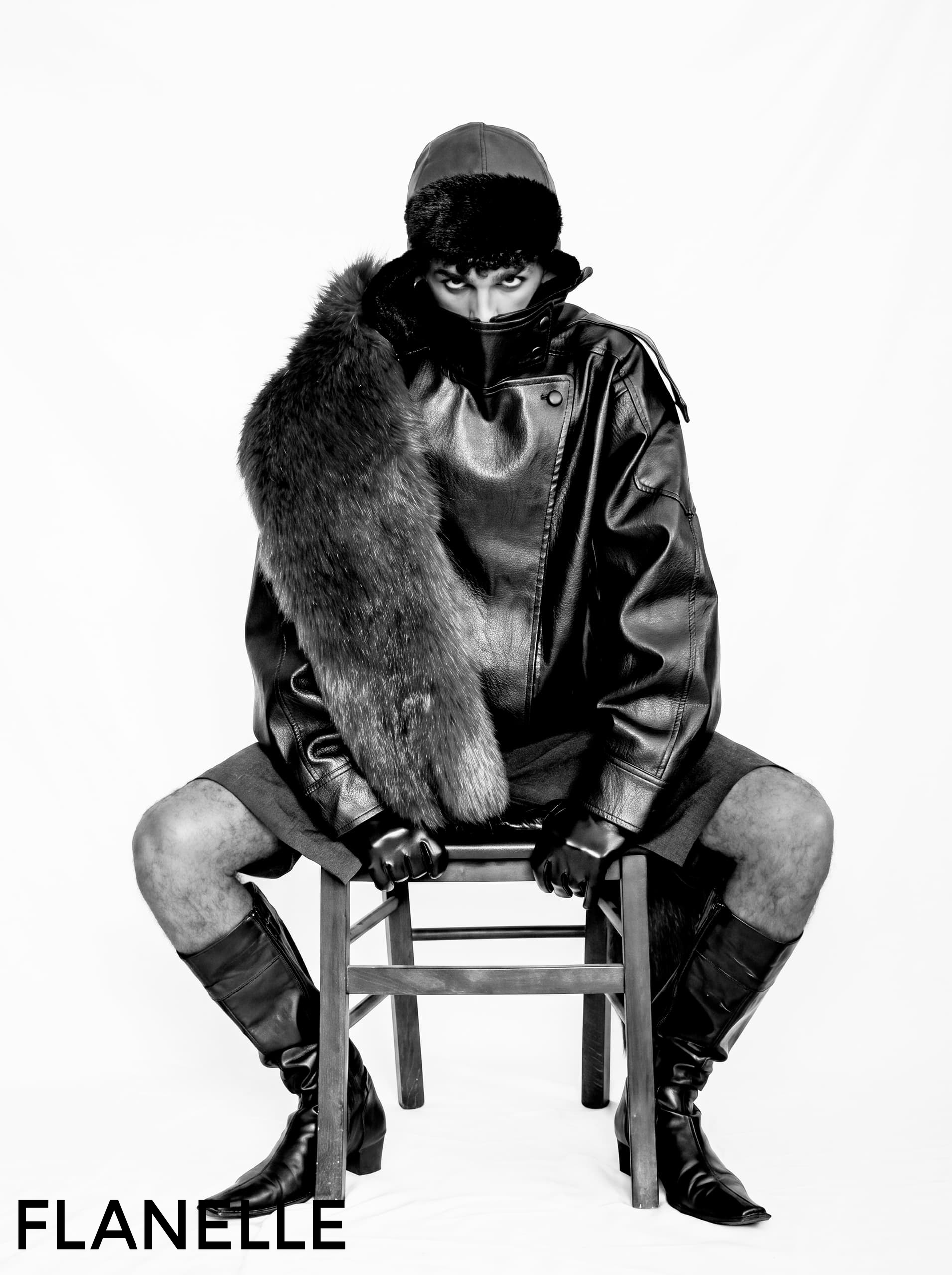 Fashionable model in leather and fur, sitting on a chair, Flanelle magazine style.