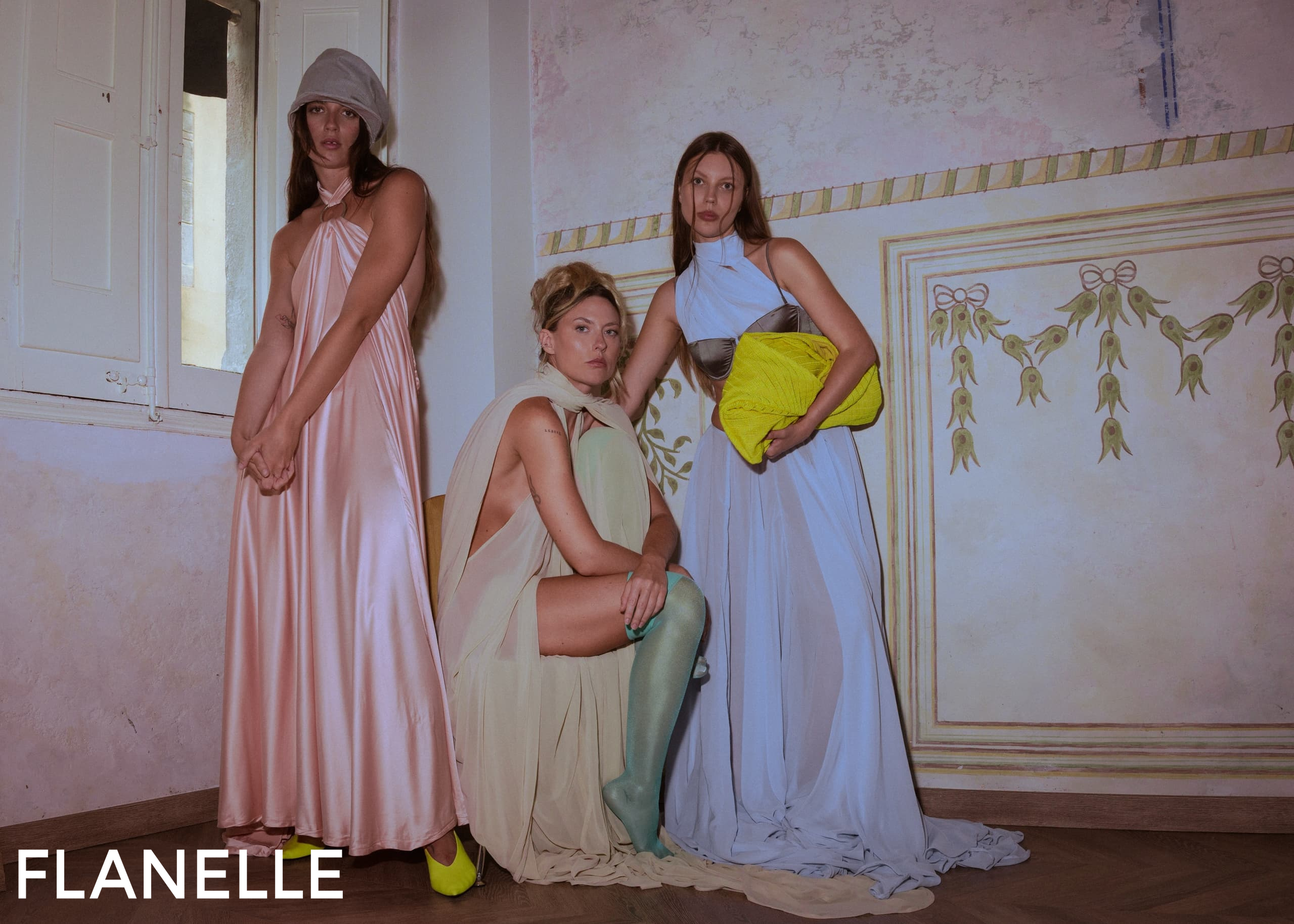 Models in elegant pastel dresses with vibrant accessories.