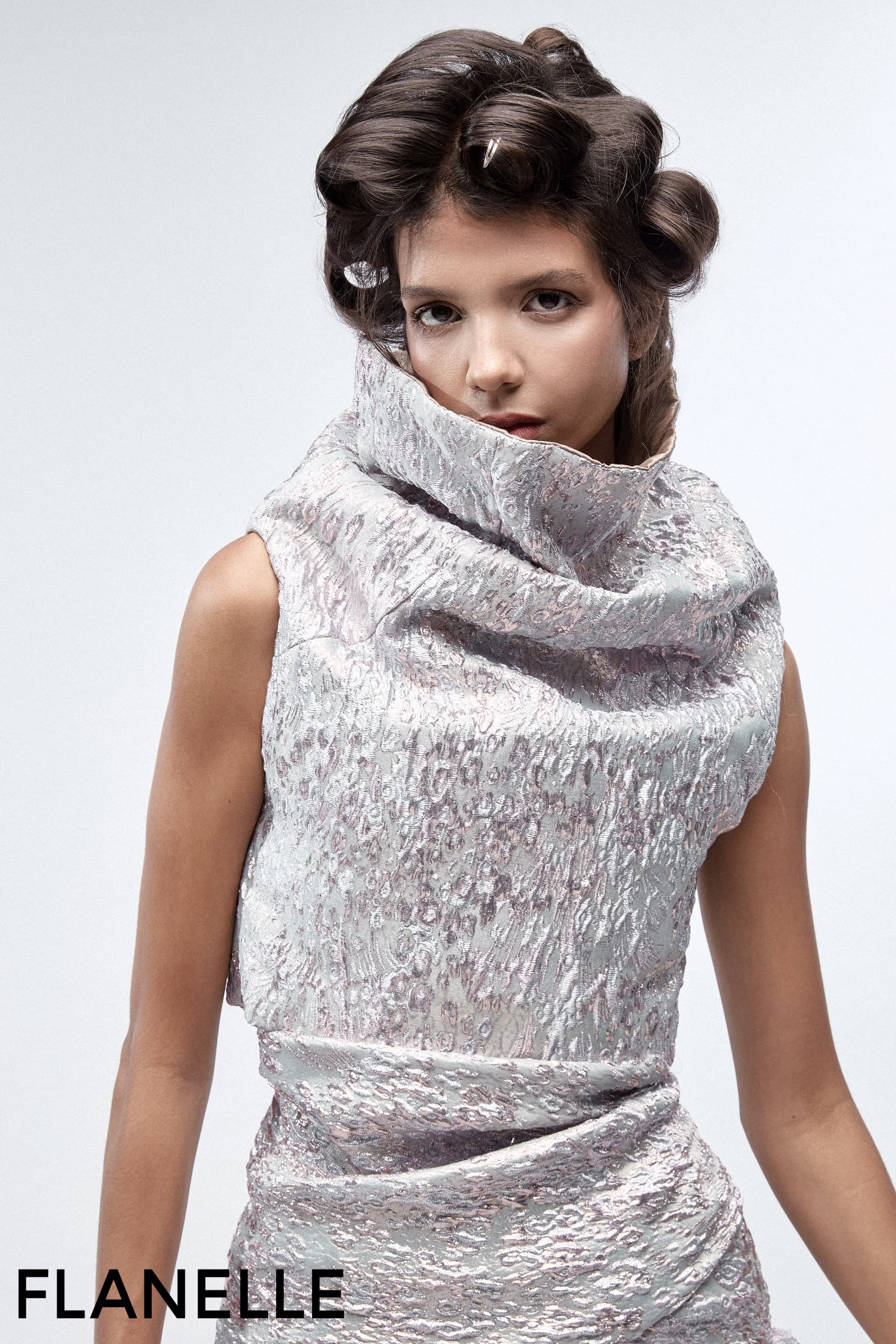 Model in elegant textured silver dress with stylish updo hairstyle.