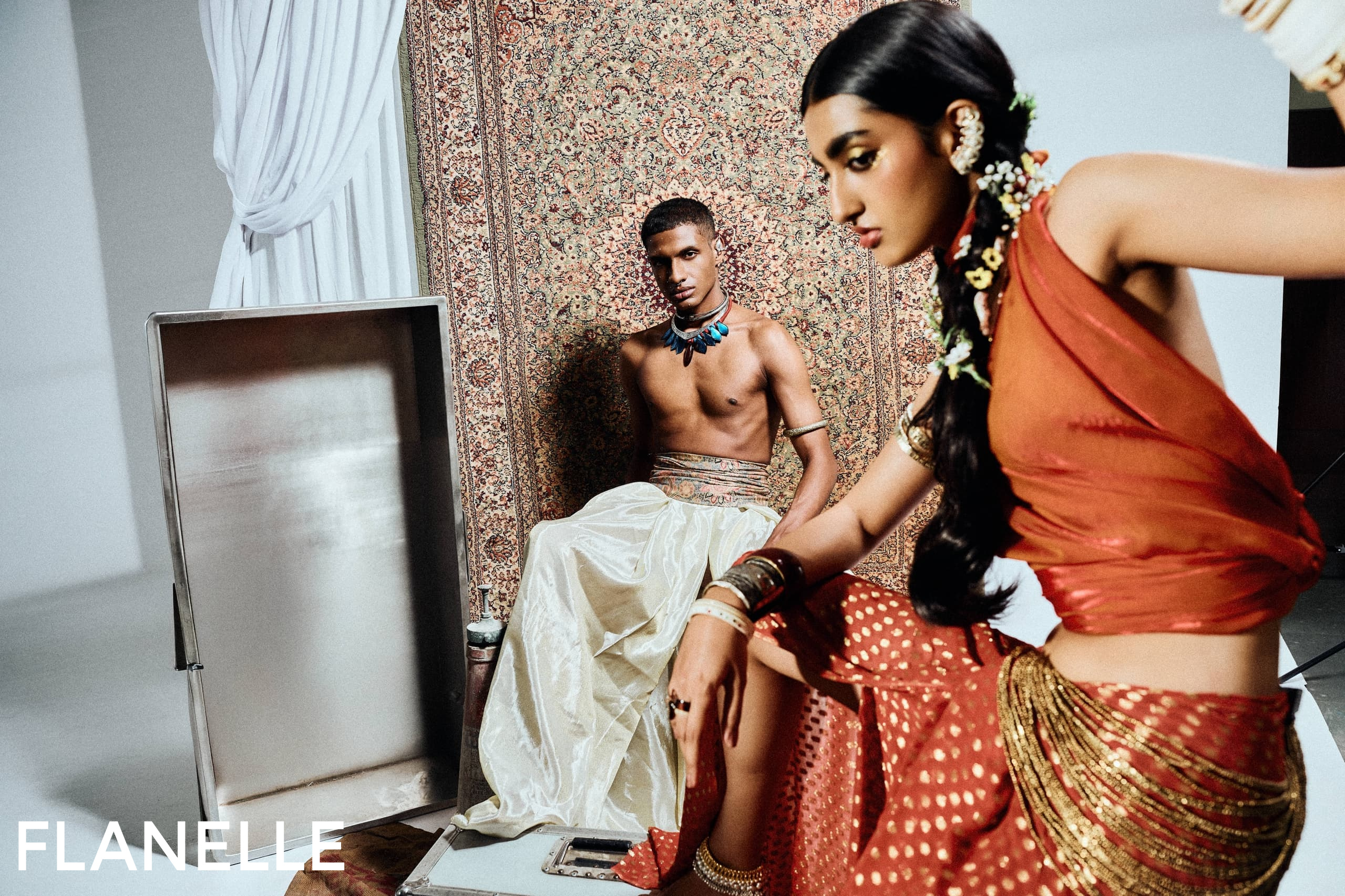 Fashion editorial with two models in traditional Indian attire, vibrant and elegant.