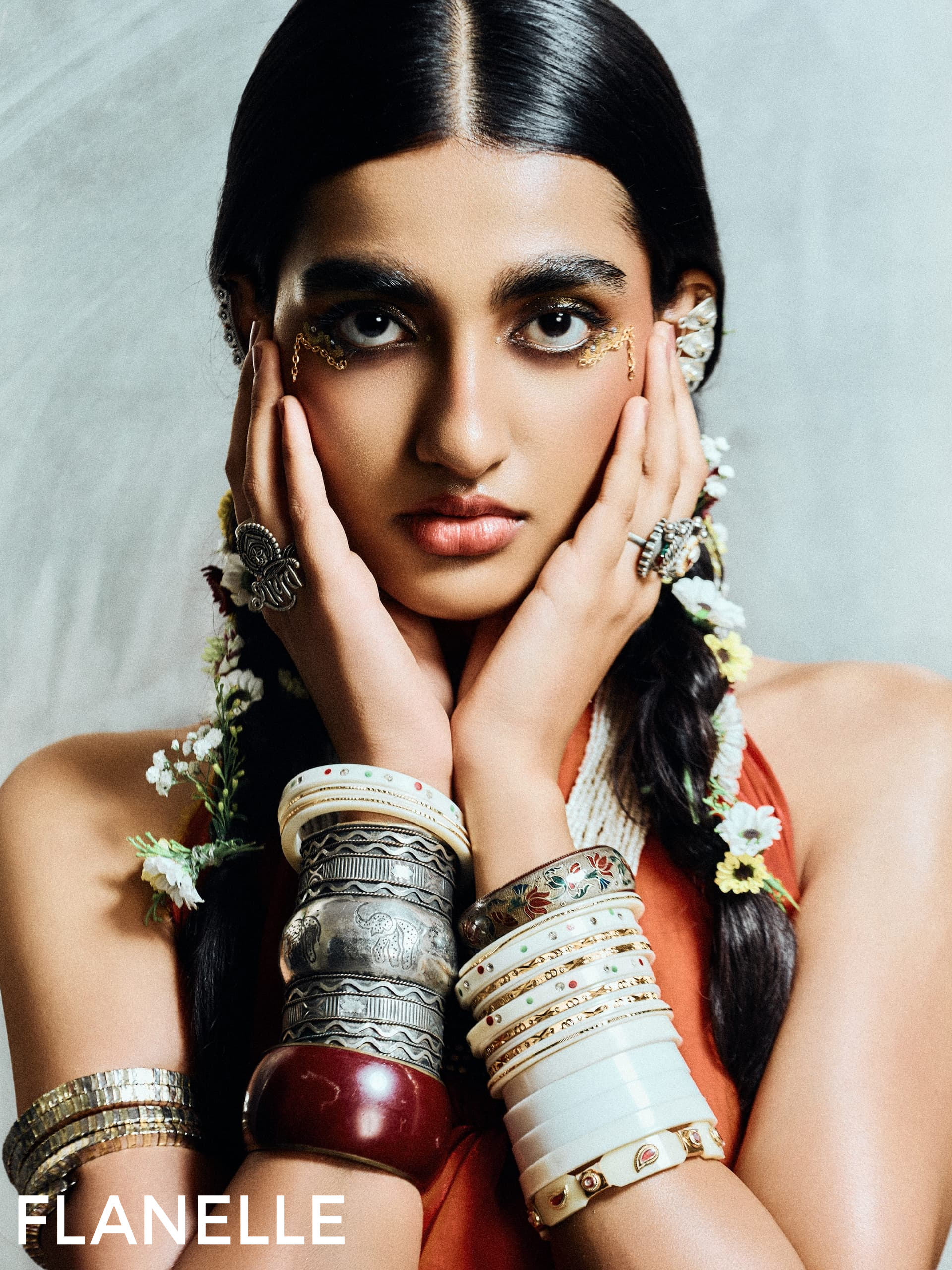 Fashion model showcasing intricate jewelry and bold makeup for Flanelle Magazine.