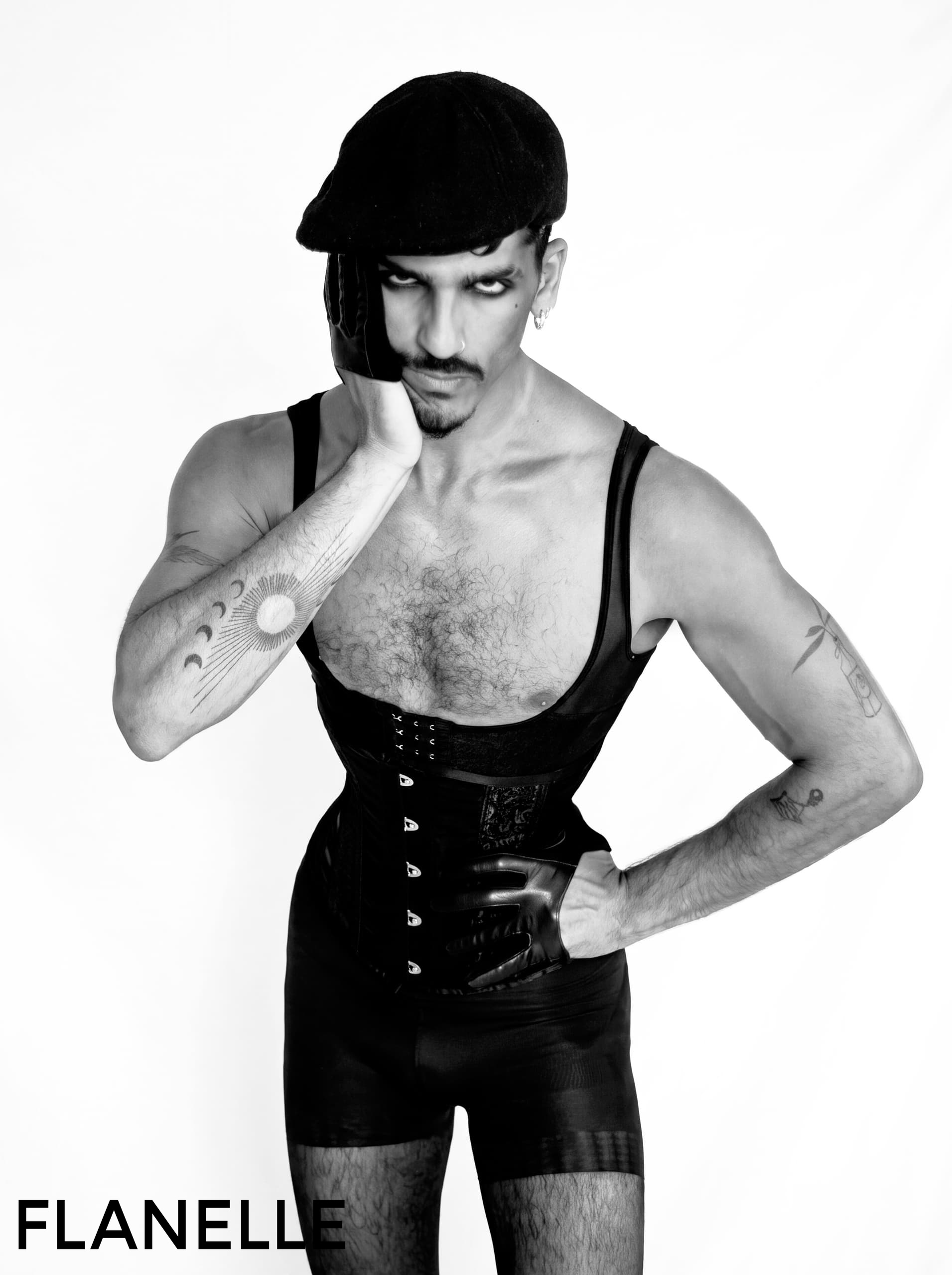 Black and white fashion portrait, model in corset and hat, striking pose.