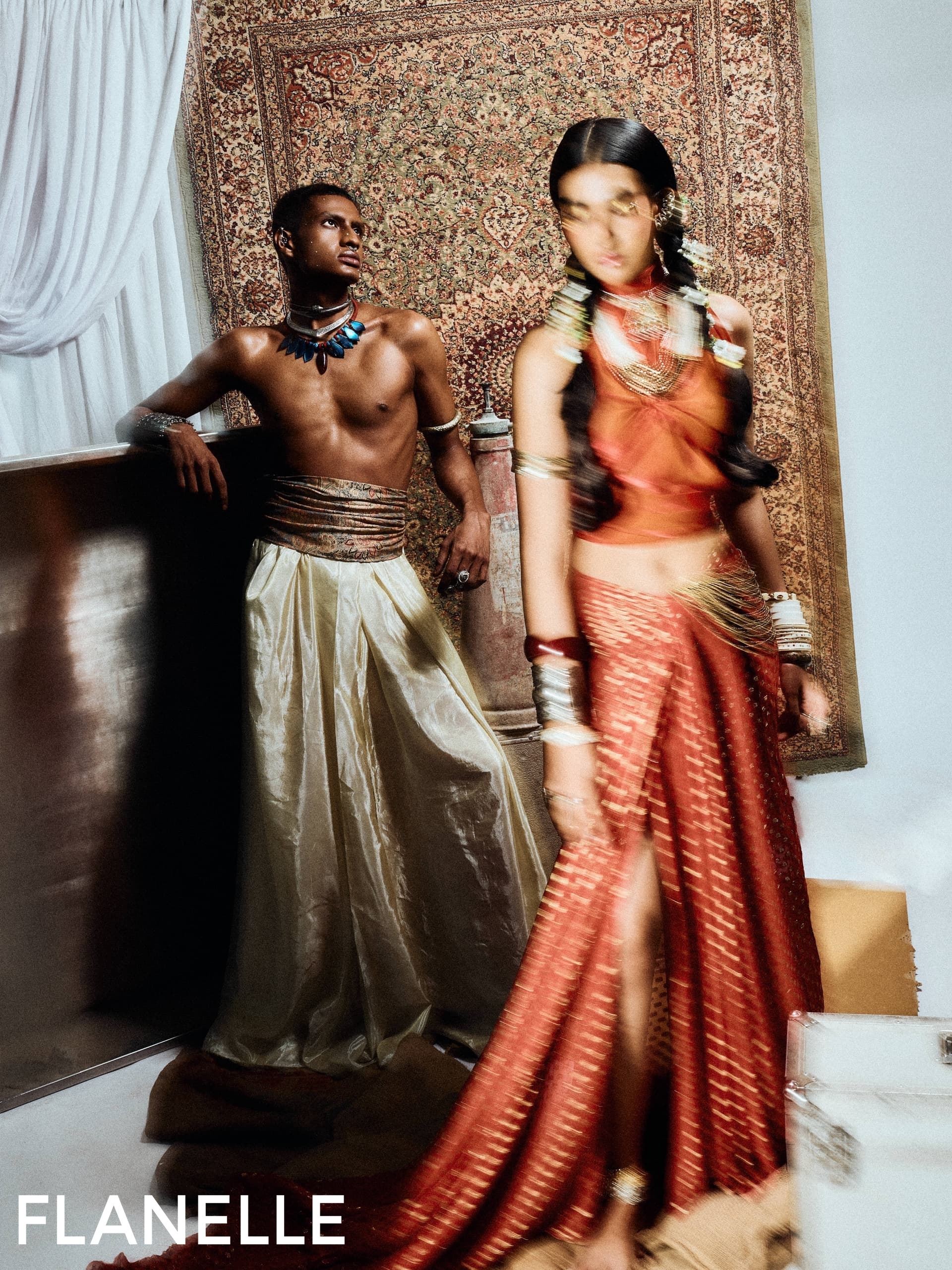 Fashion editorial with elegant models in vibrant, flowing garments and rich tapestry.