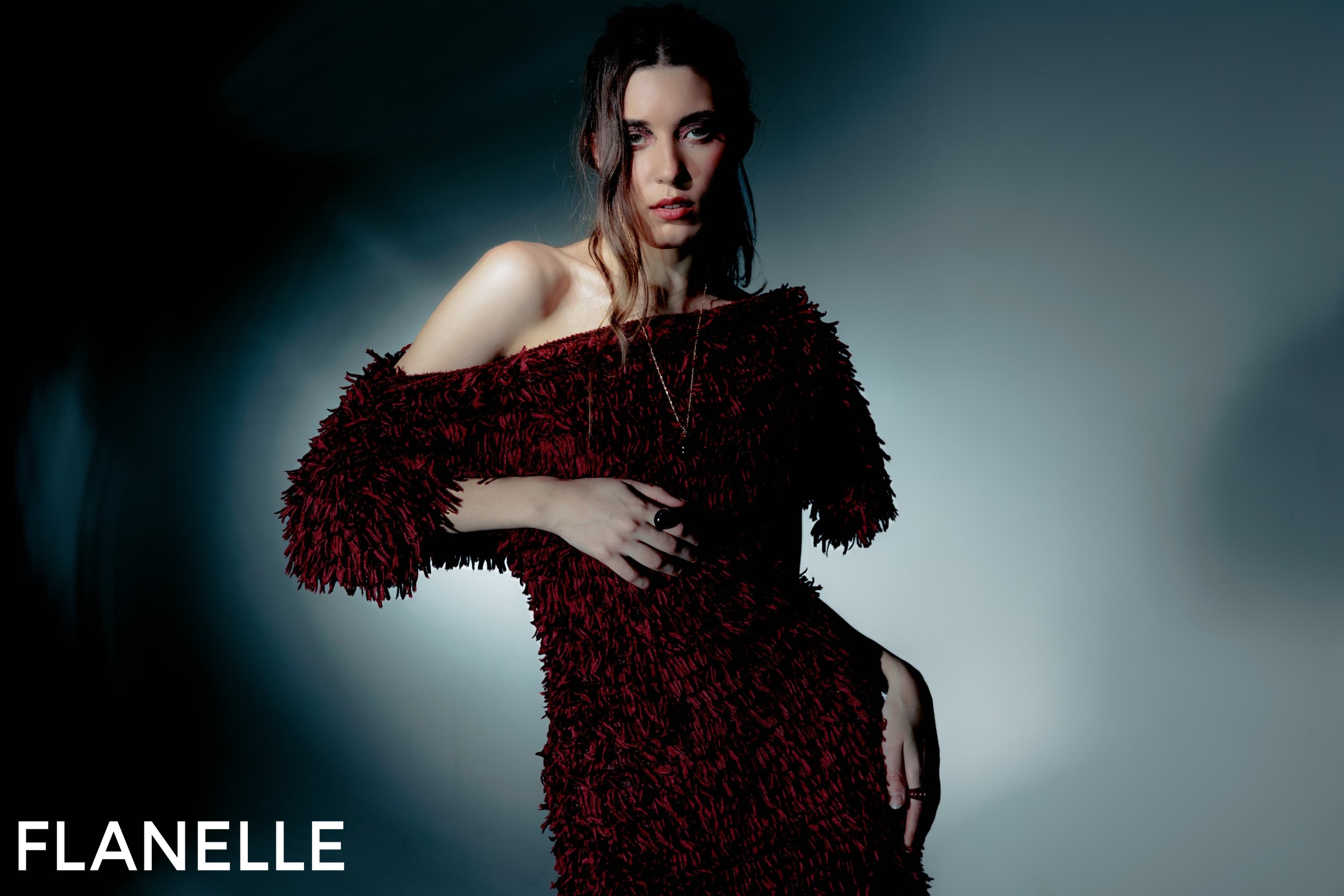 Fashion model in textured burgundy dress for Flanelle magazine photoshoot.