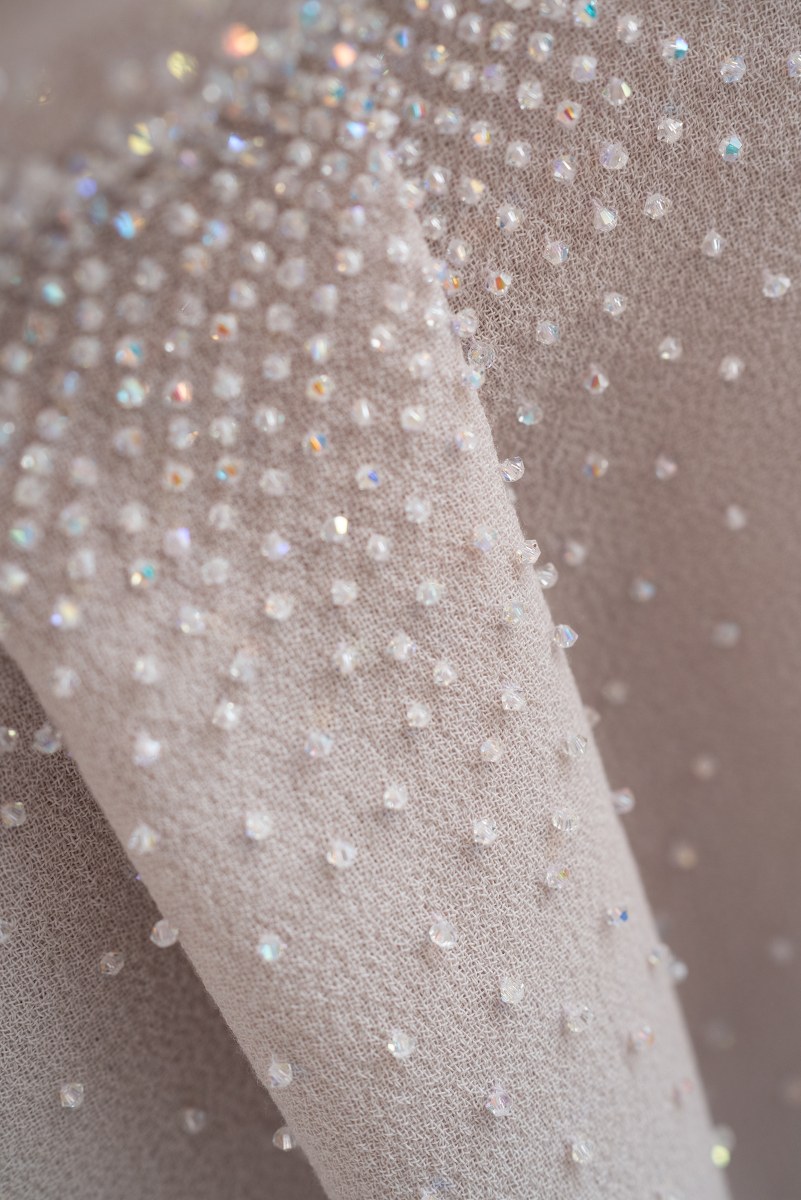 Close-up of fabric with sparkling crystal embellishments.