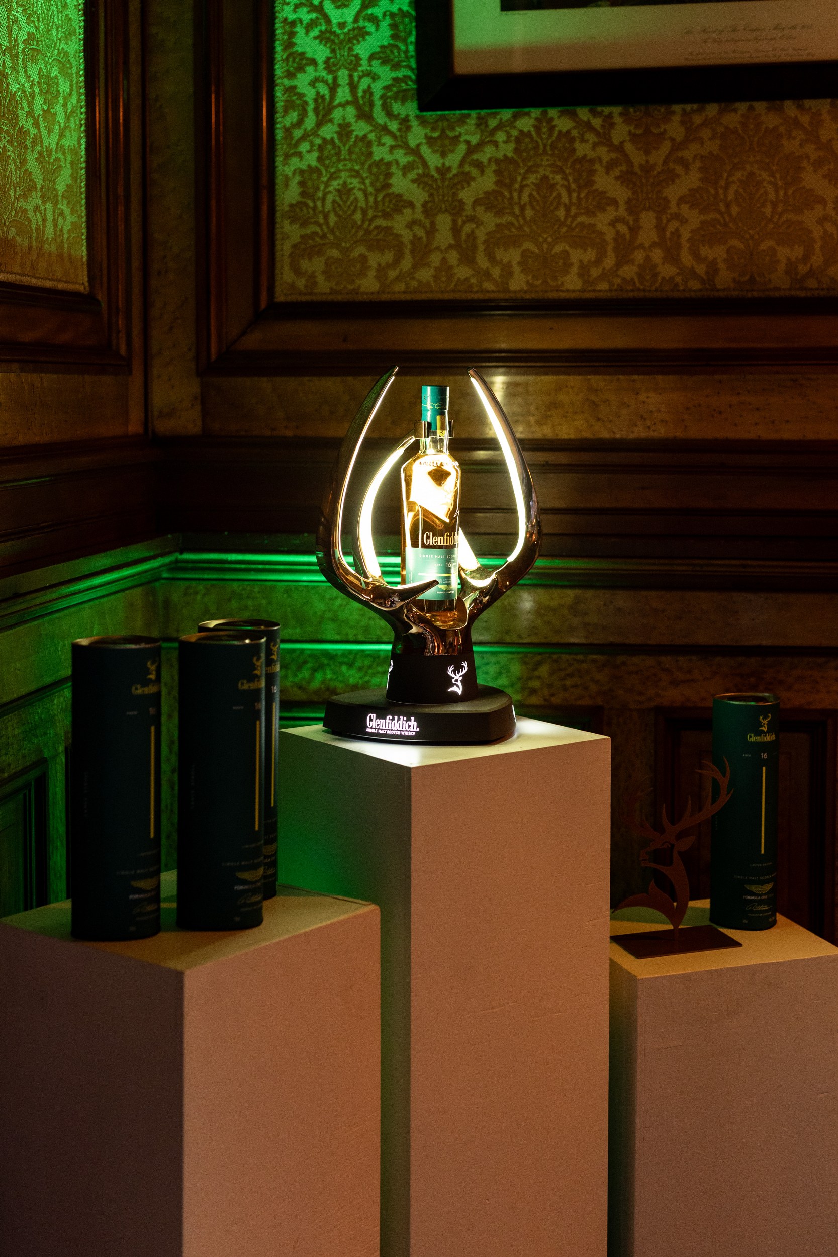 Bottle of Glenfiddich whisky elegantly displayed in a lit-up antler holder.