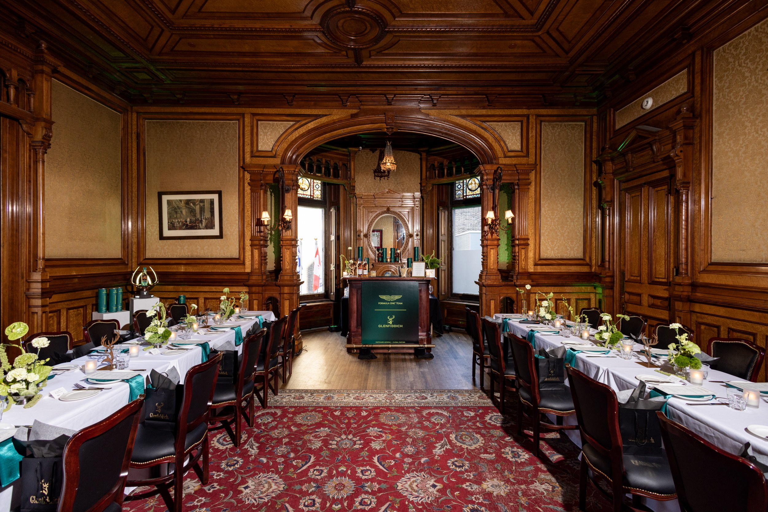 Elegant vintage dining room set for a formal dinner with wooden decor and chandeliers.