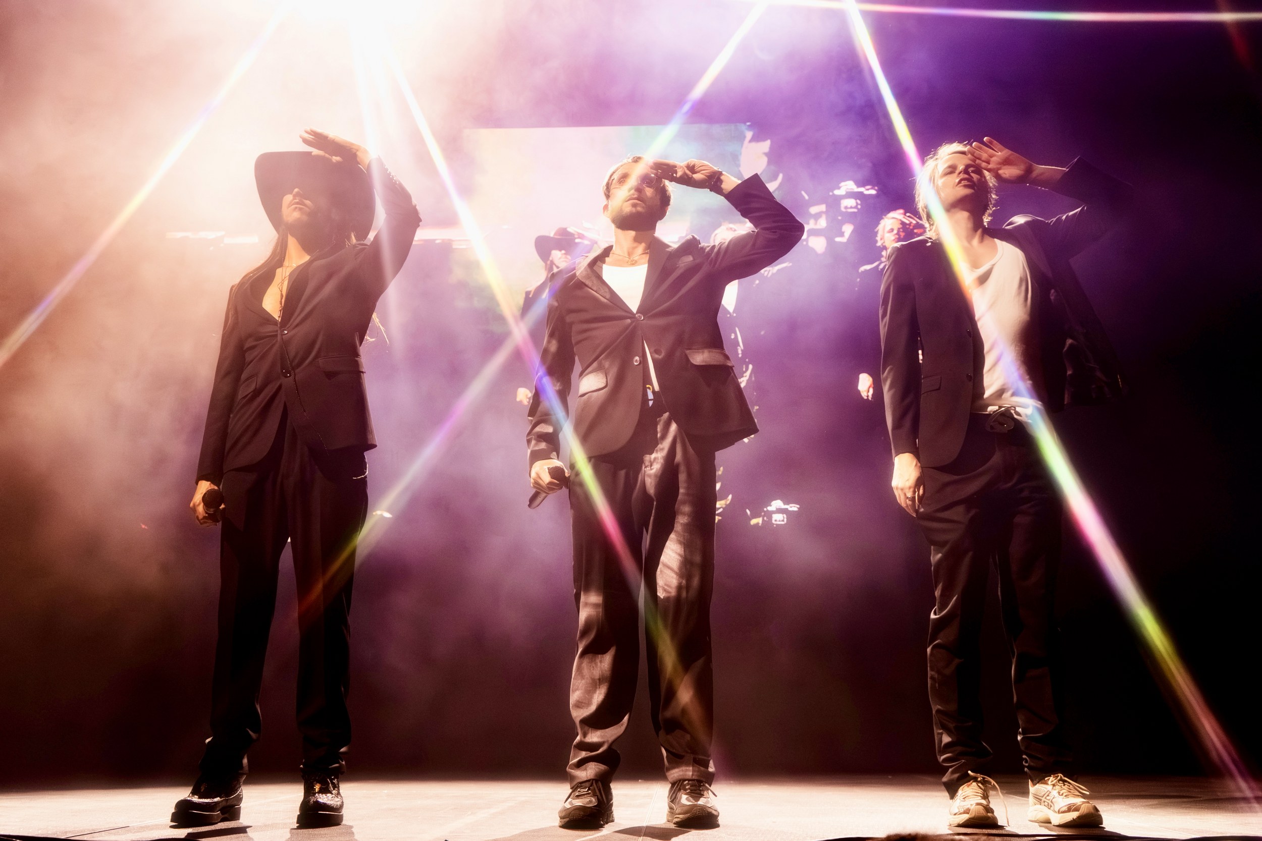 Performers on stage with dramatic lighting and smoke effects.