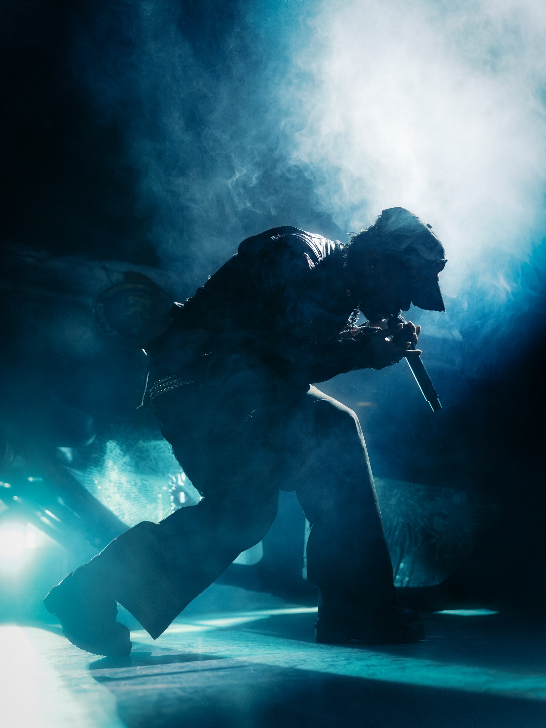 Silhouetted performer on stage with smoke and dramatic lighting.