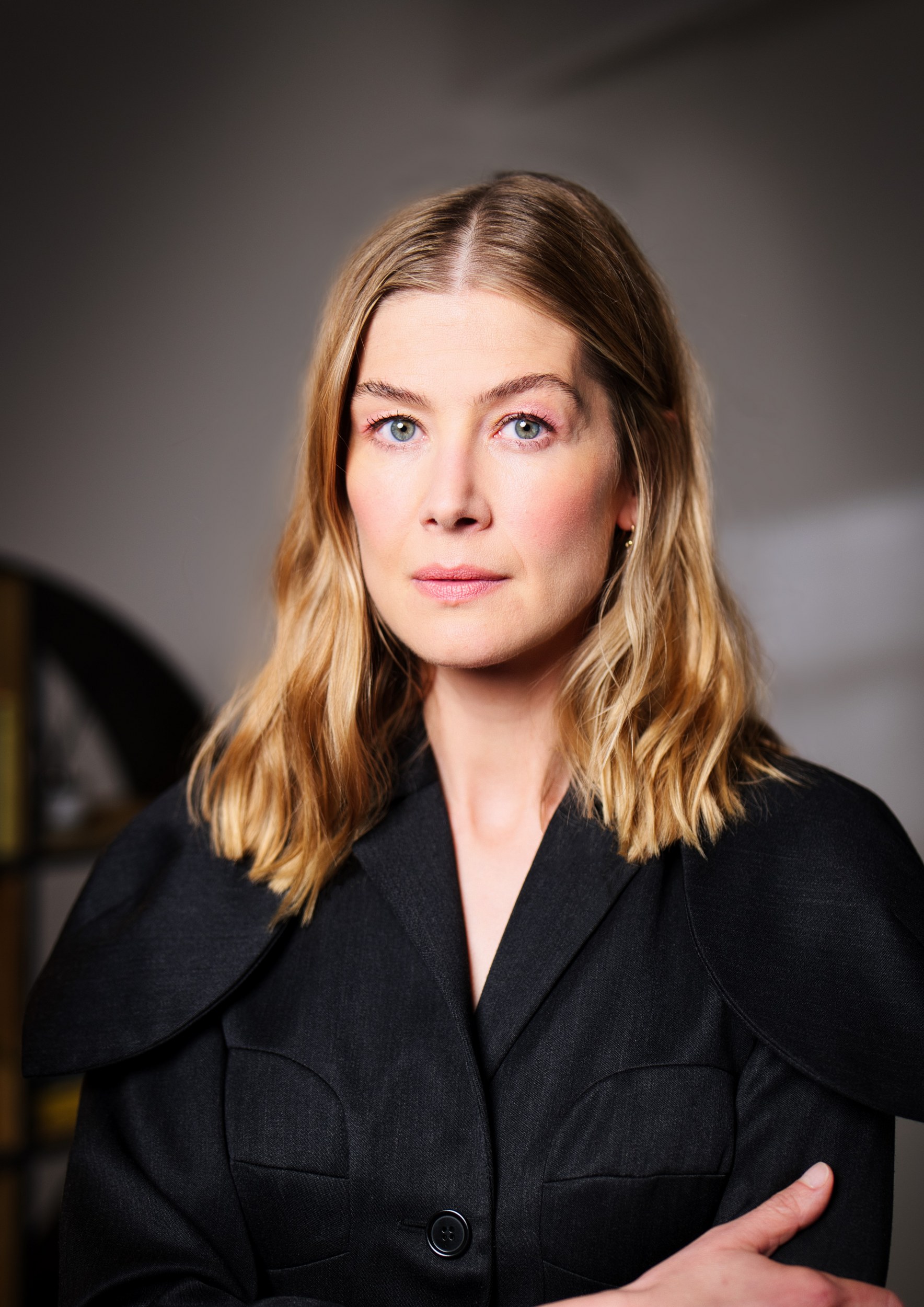 Professional woman in black blazer with blonde hair, looking confidently at the camera.