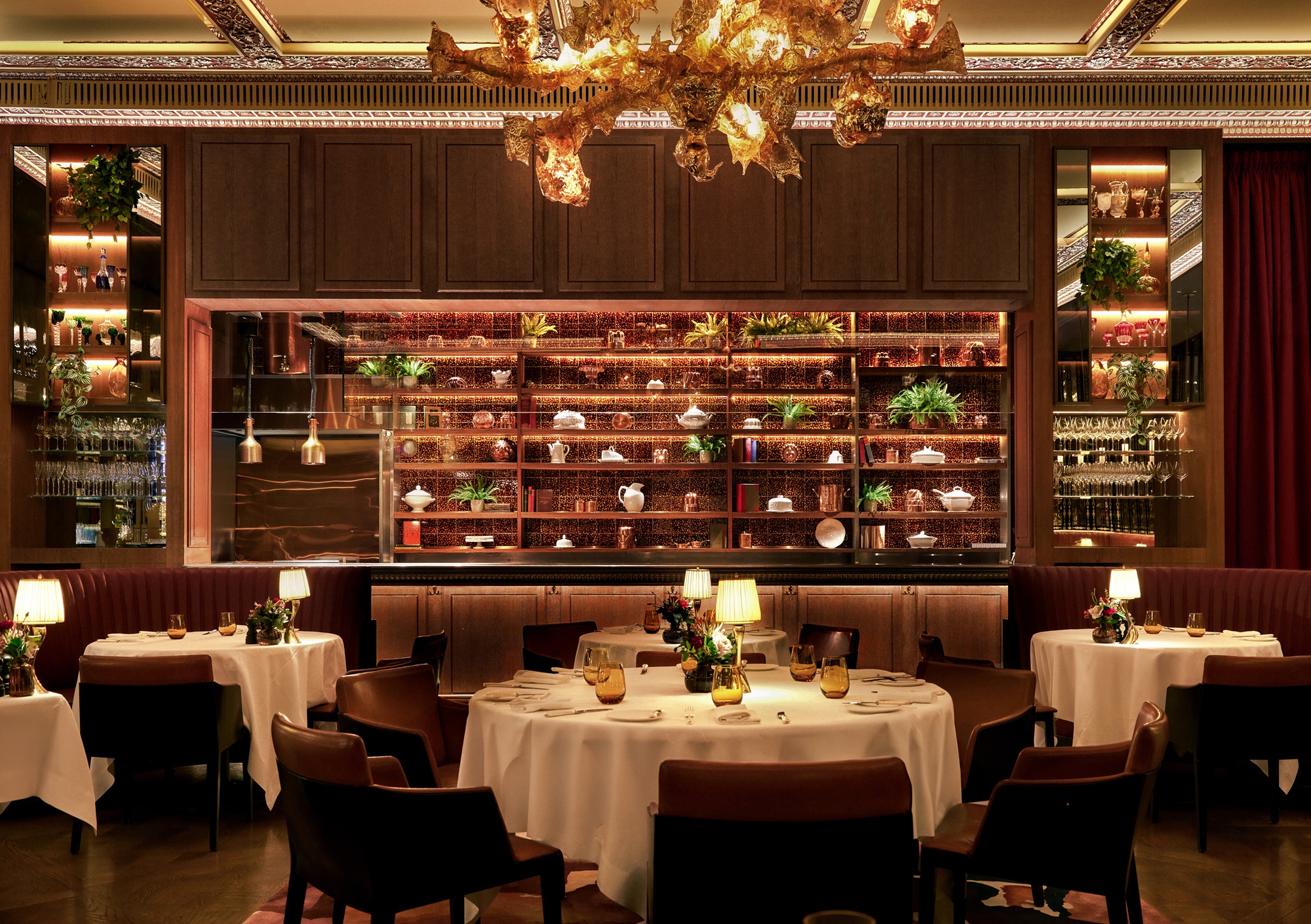 Luxurious restaurant interior with elegant tables and warm lighting.