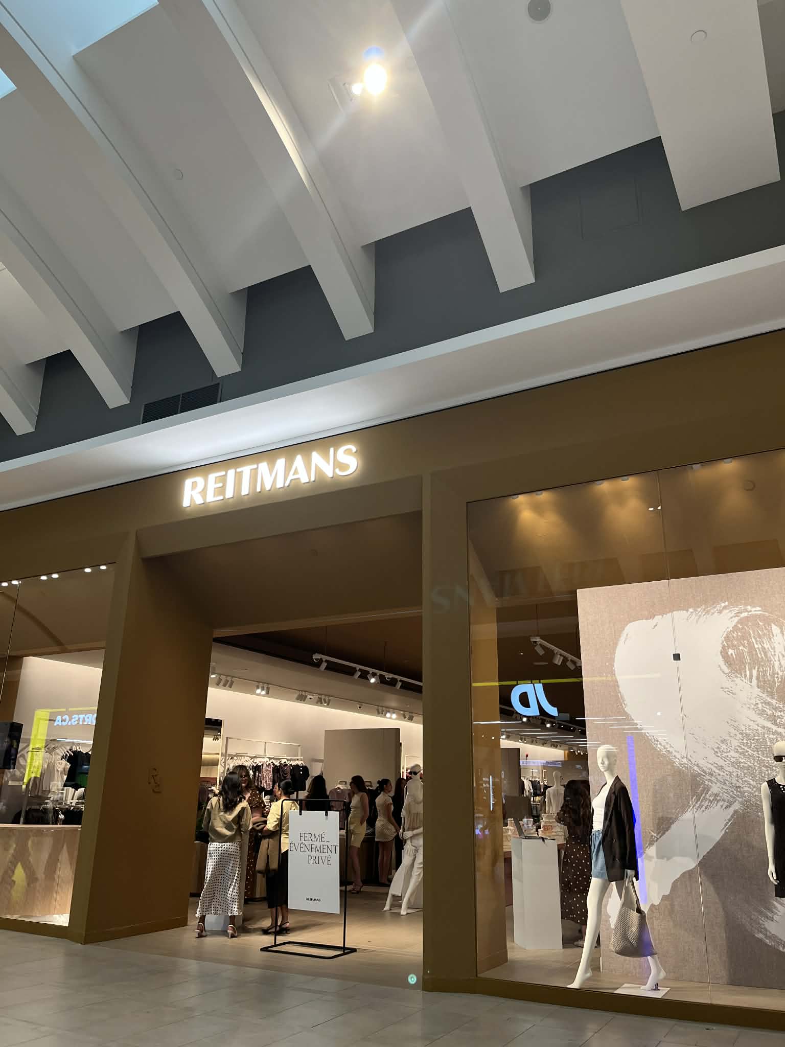Reitmans store entrance with shoppers during a private event.