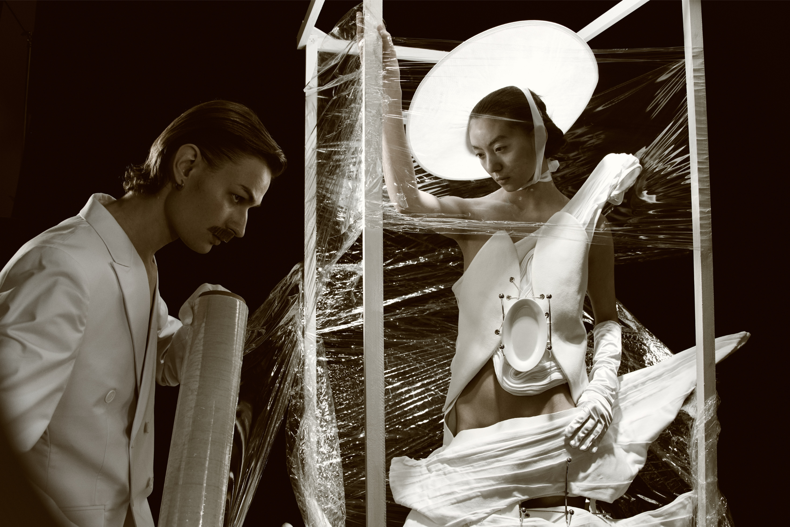 Avant-garde fashion art with models in creative, abstract attire and setting.