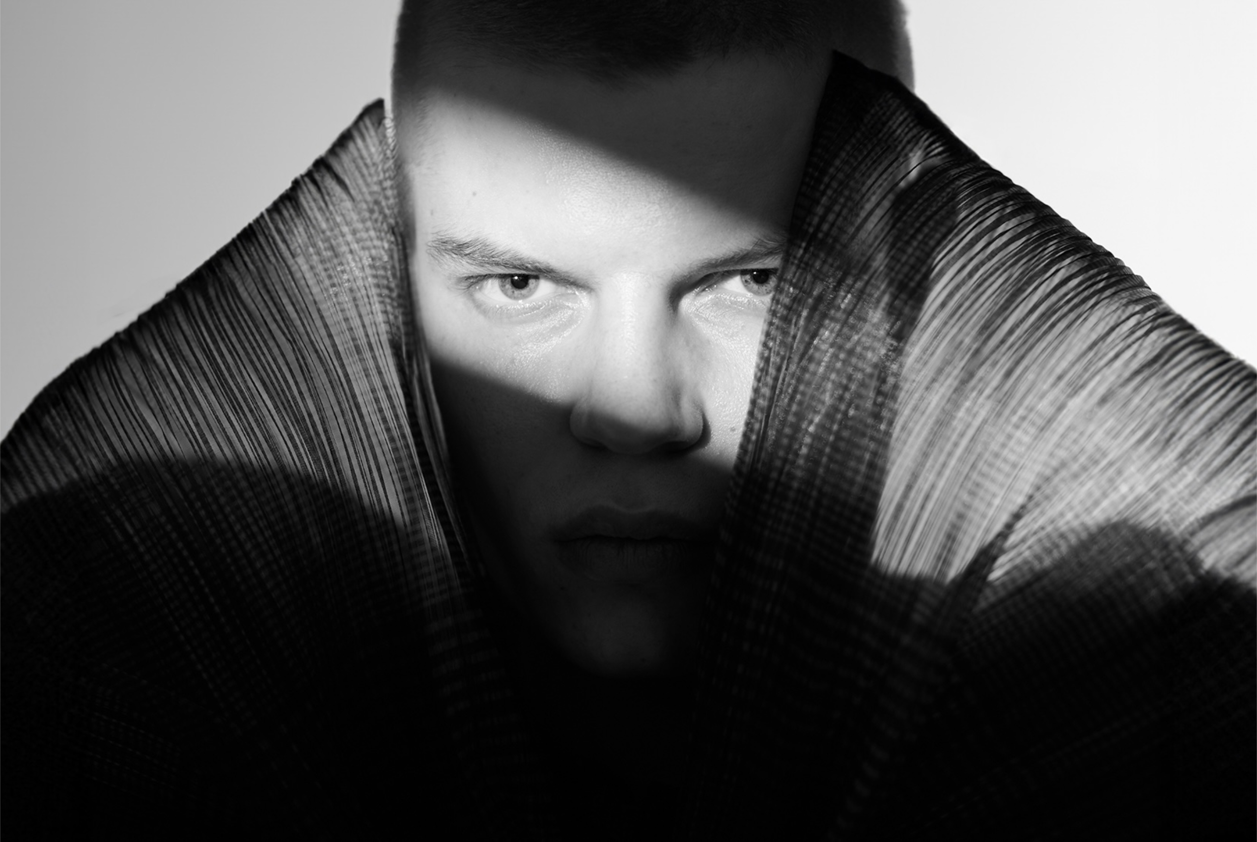 Moody black and white portrait with dramatic shadows and textured collar.