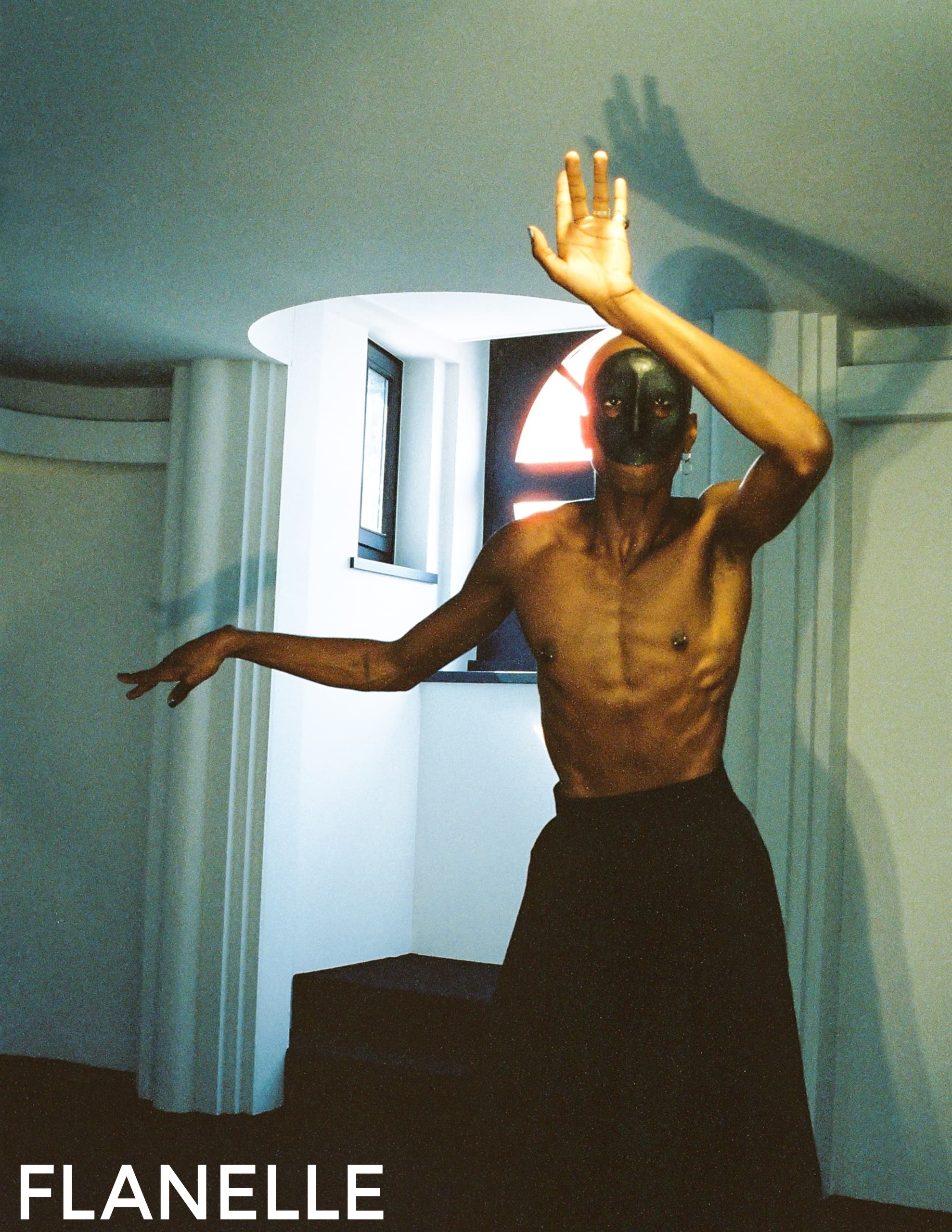 Artistic dancer posing dramatically in a moody, modern setting.