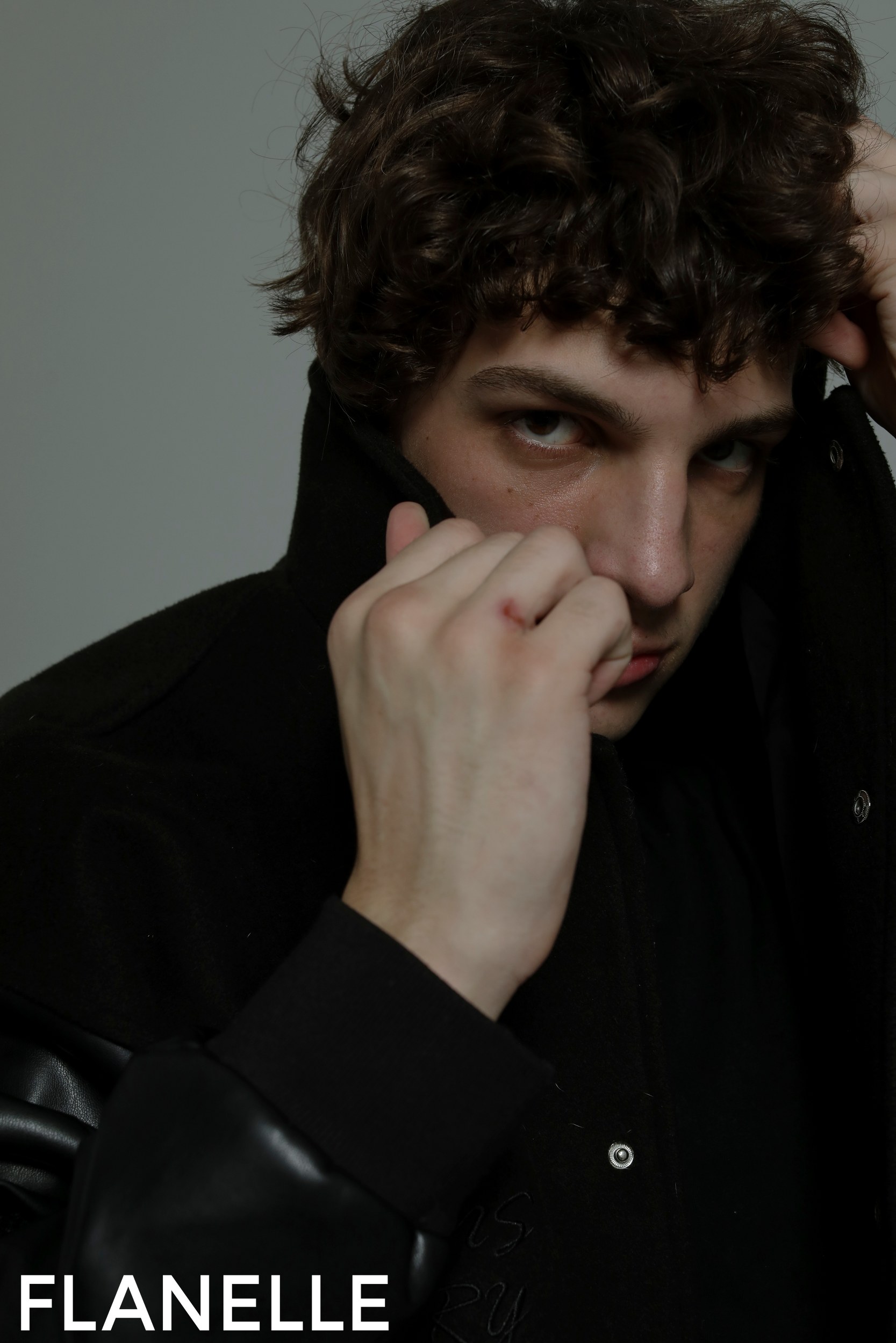 Man in dark jacket posing for Flanelle fashion magazine cover.