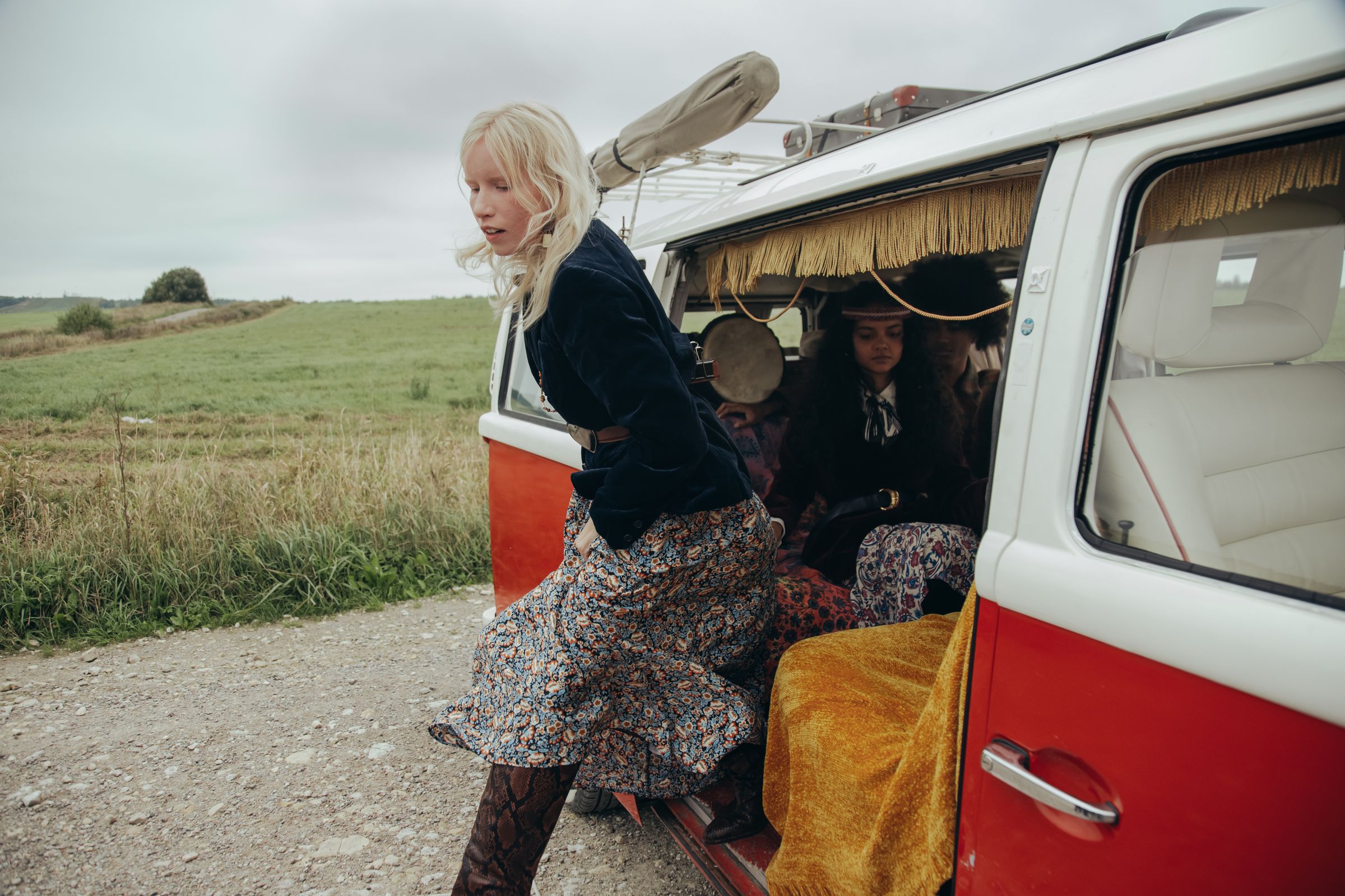 Woman exiting vintage van in countryside setting.