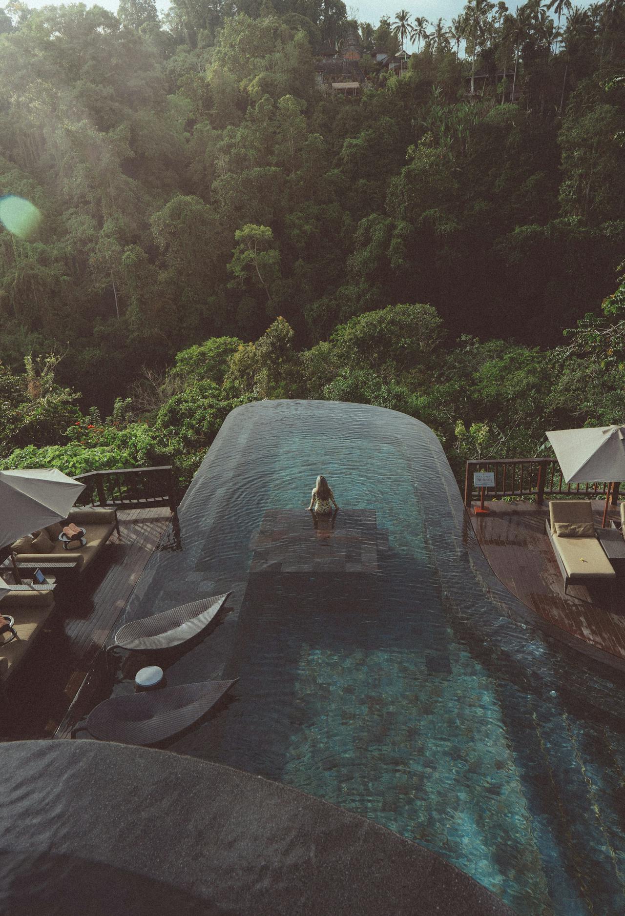 Infinity pool overlooking lush forest, perfect for a relaxing retreat.