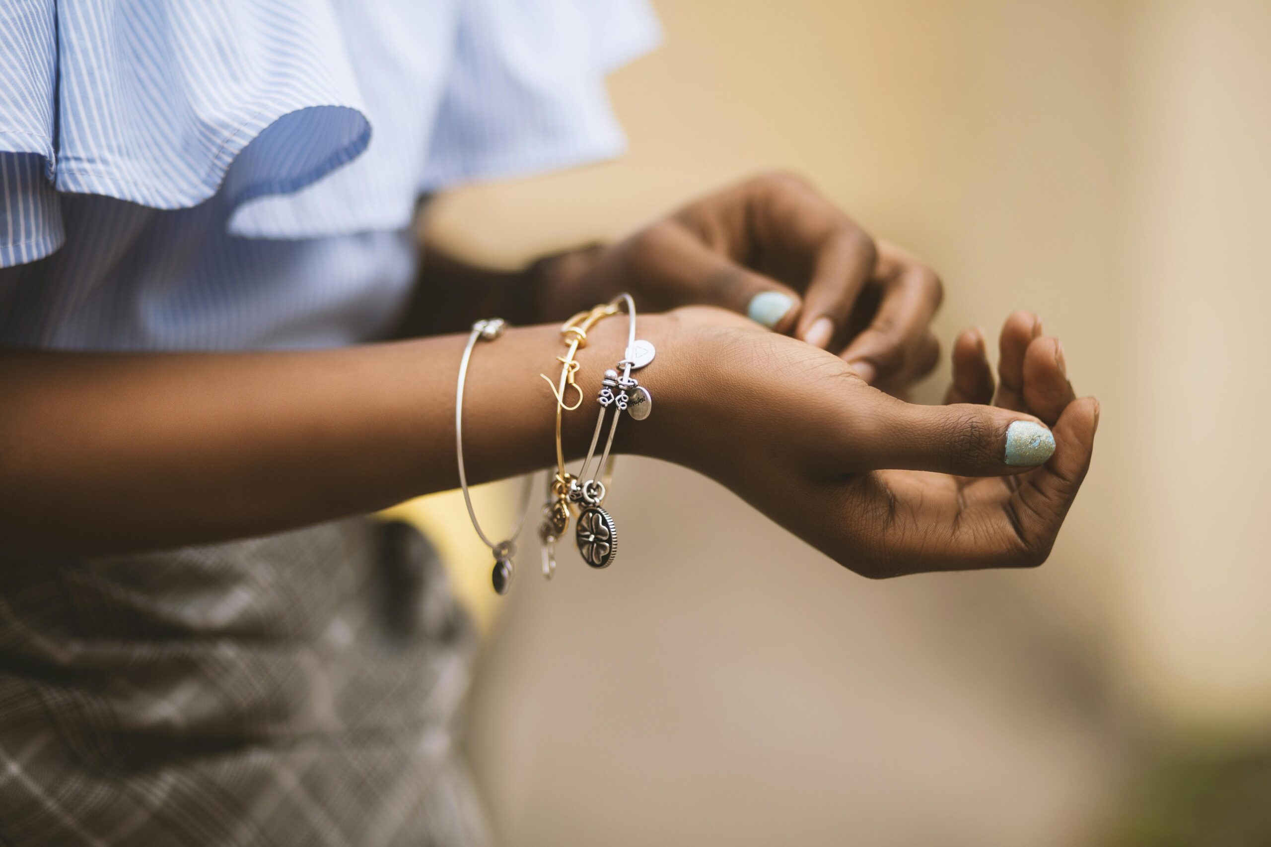 Close-up of stylish charm bracelets on a woman's wrist.