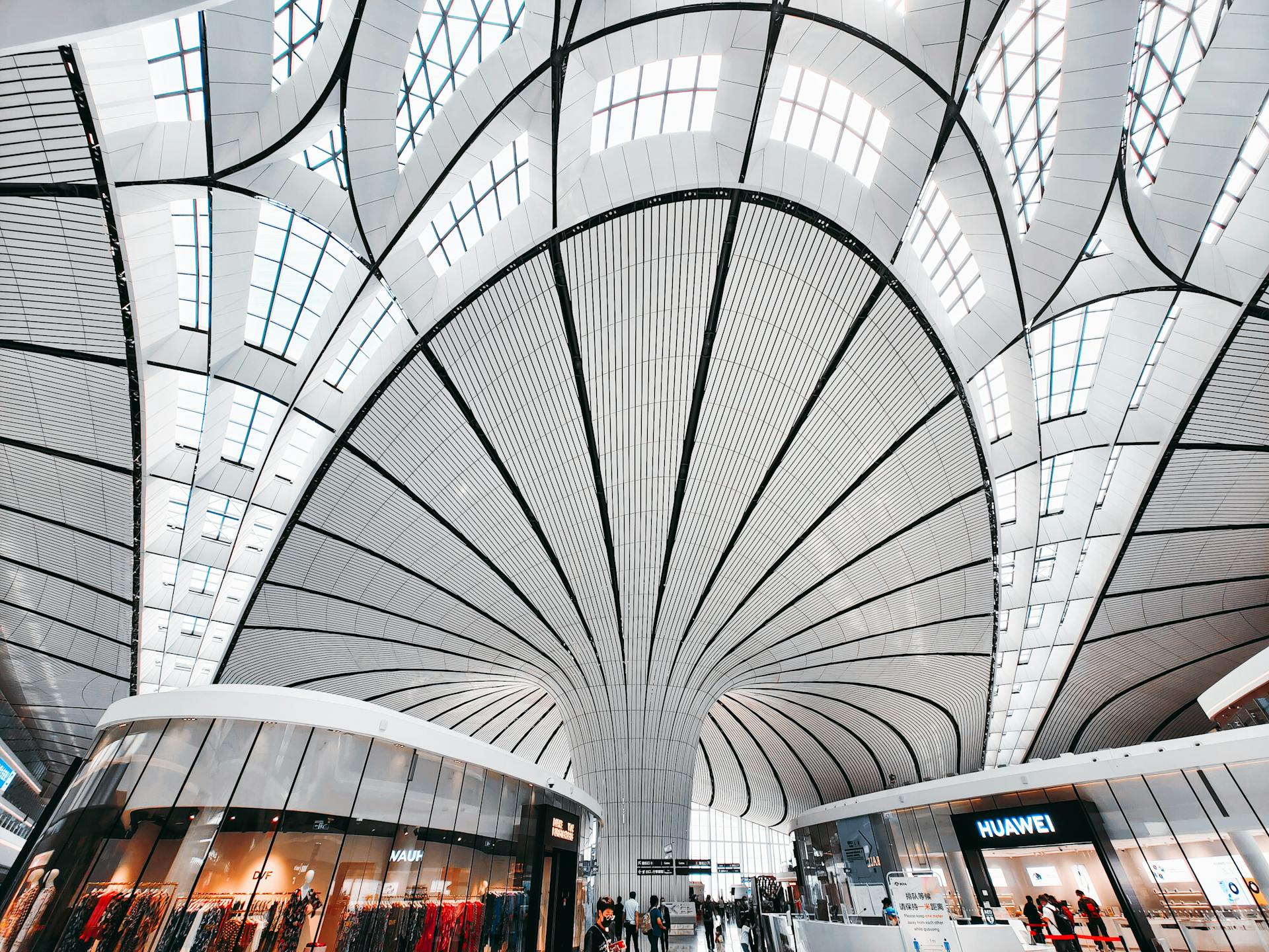Modern architectural ceiling with curved design in a spacious public area.