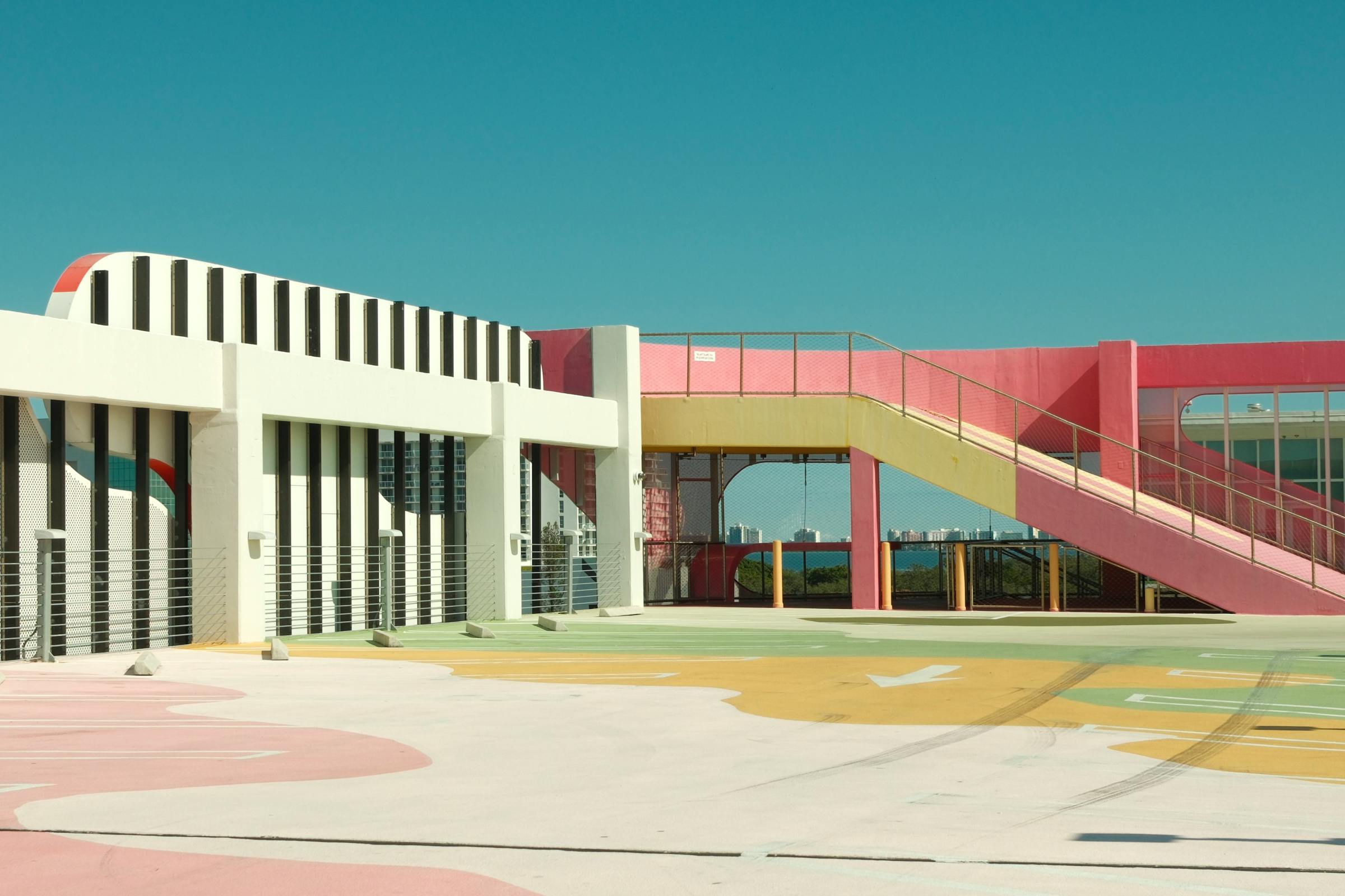 Colorful modern architecture with pink and yellow accents under a clear blue sky.